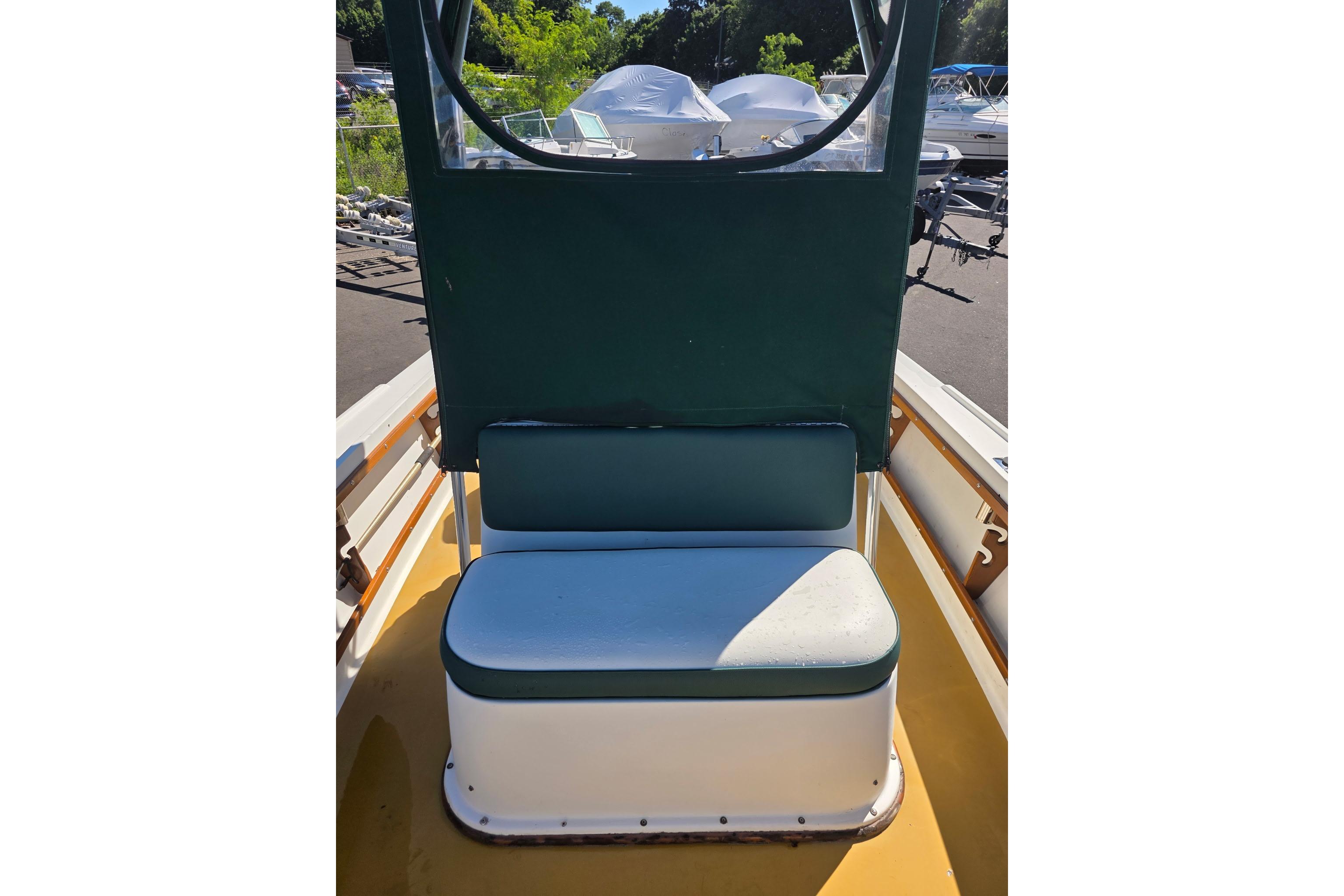 1982 Mako 20 Center Console boat interior with green seating and canopy.