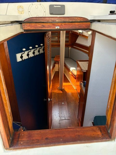 View into the cabin of a 1983 C&C Landfall with wood interior and seating area.