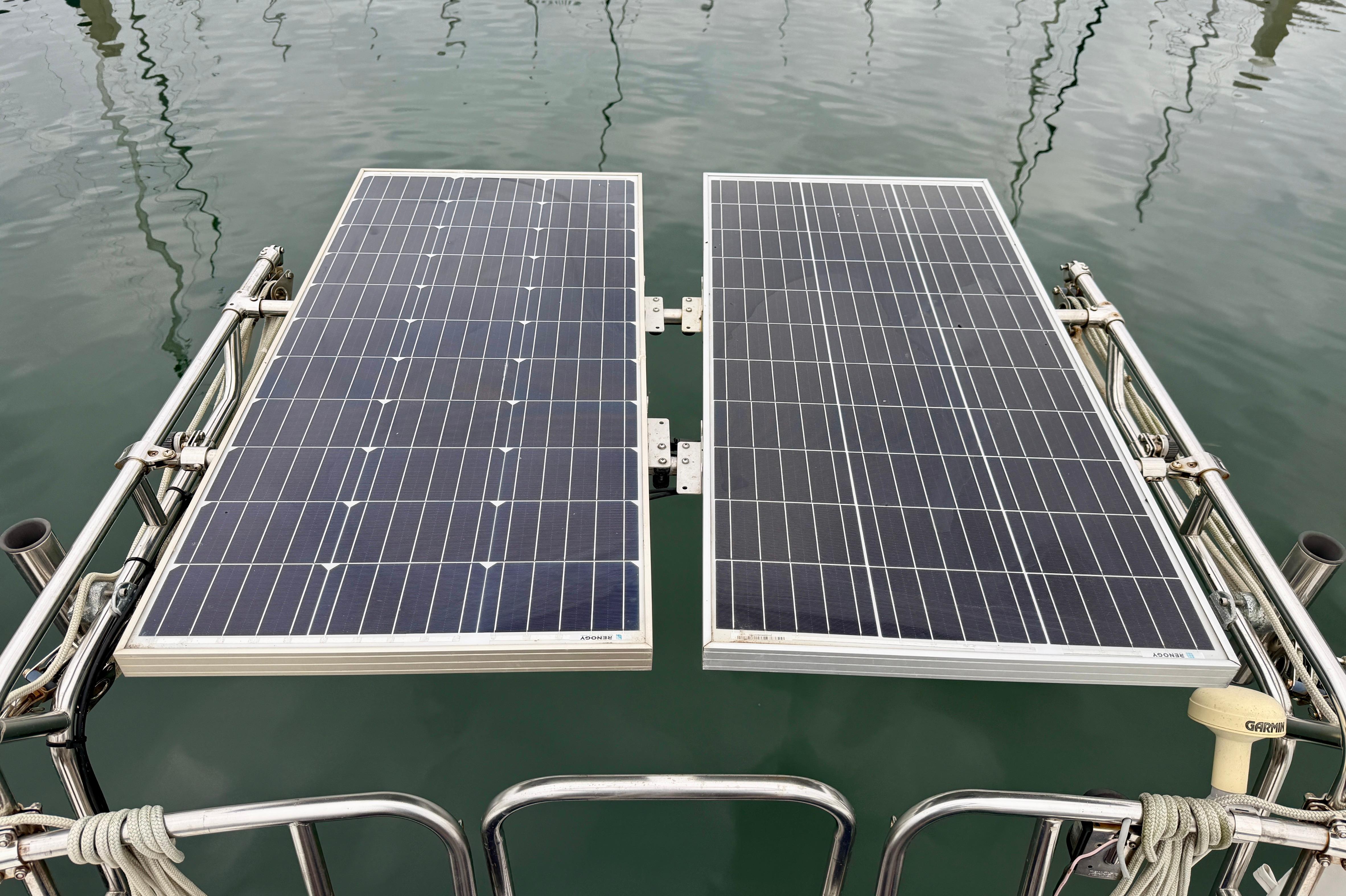 Solar panels on a 1982 Catalina 30 sailboat, reflecting on calm water.