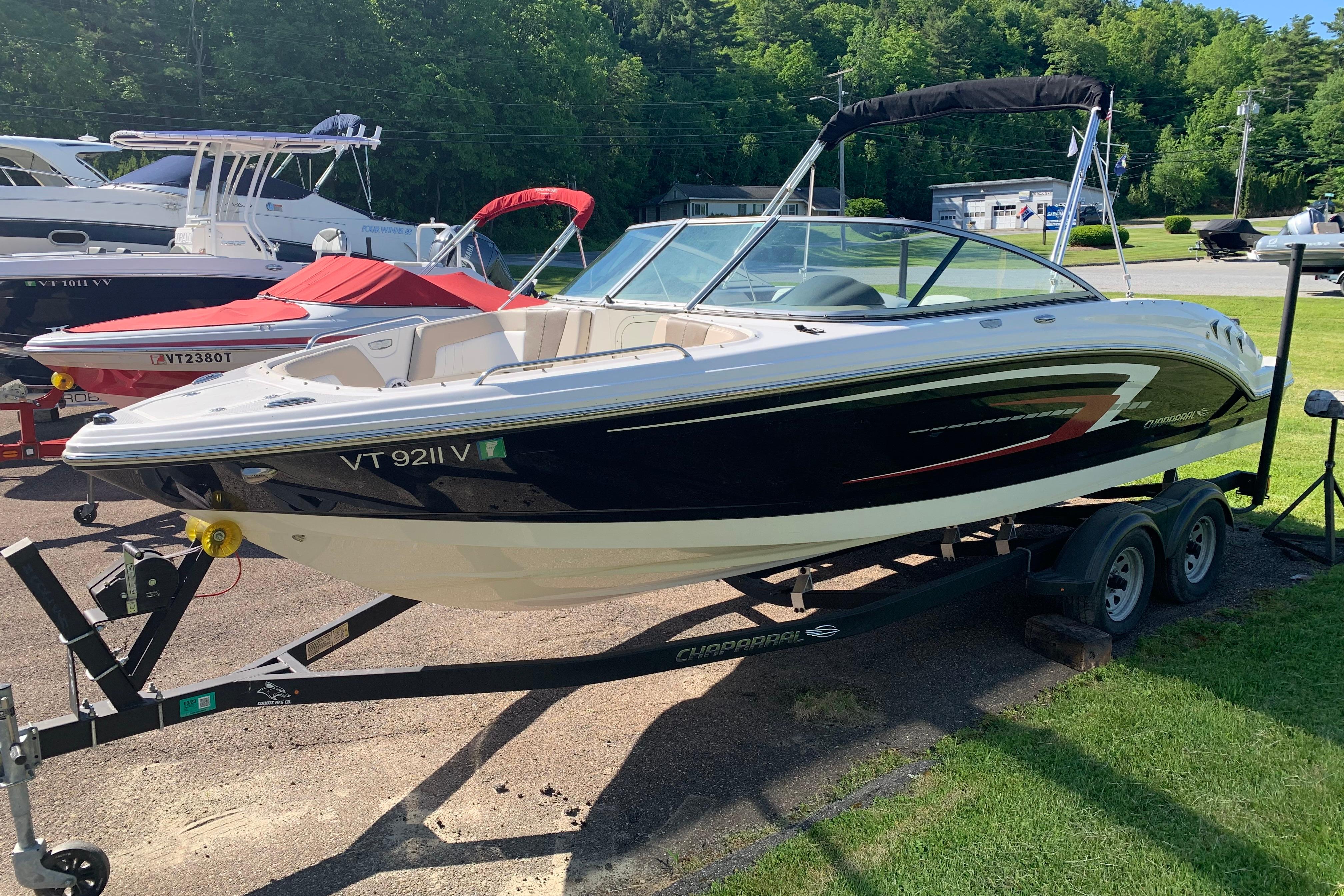 2022 Chaparral 23 SSi boat on trailer, parked outdoors in a sunny setting.