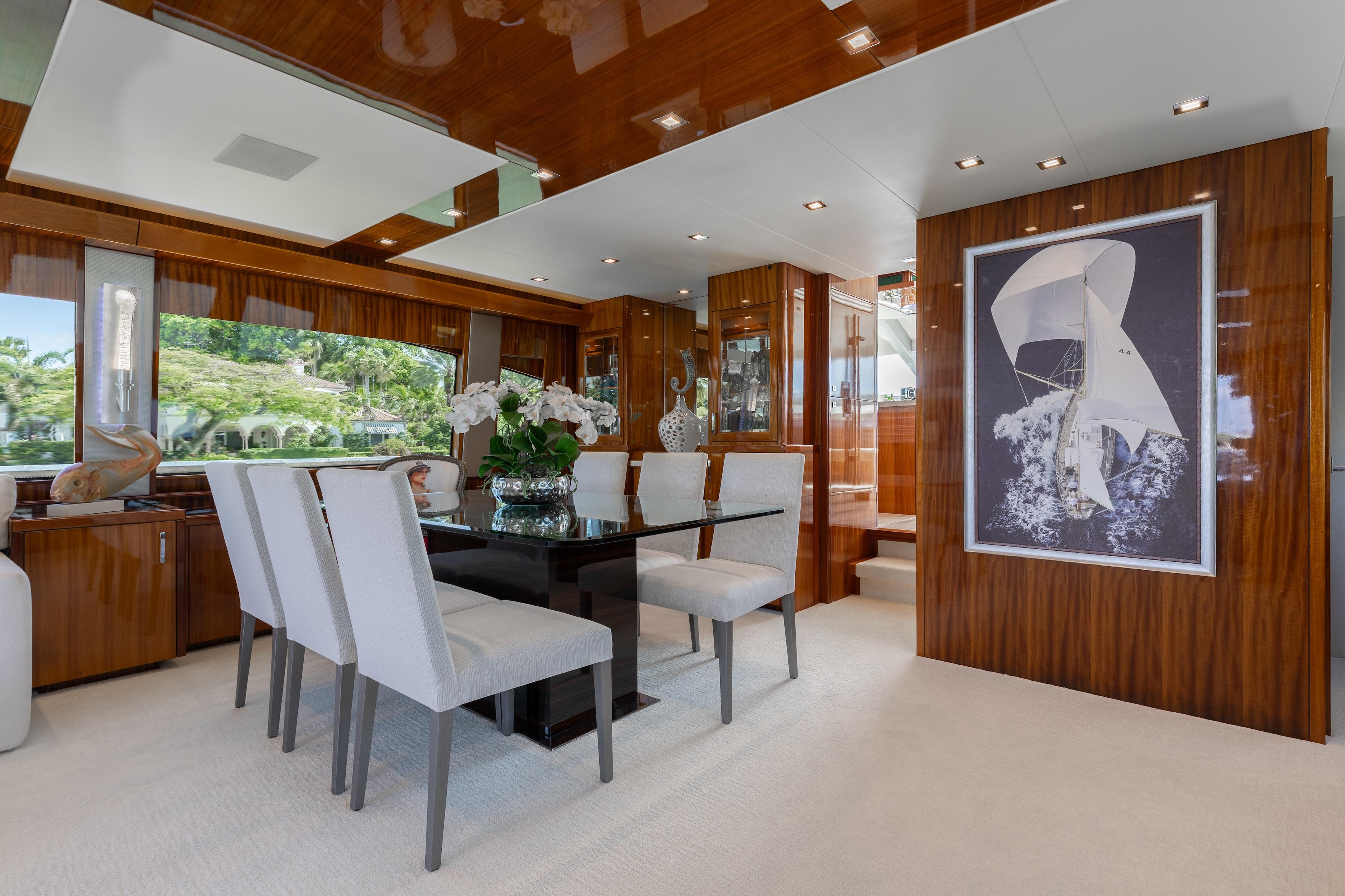 Luxurious dining area in 2014 Hatteras 80 Motor Yacht Sky Lounge with elegant decor.