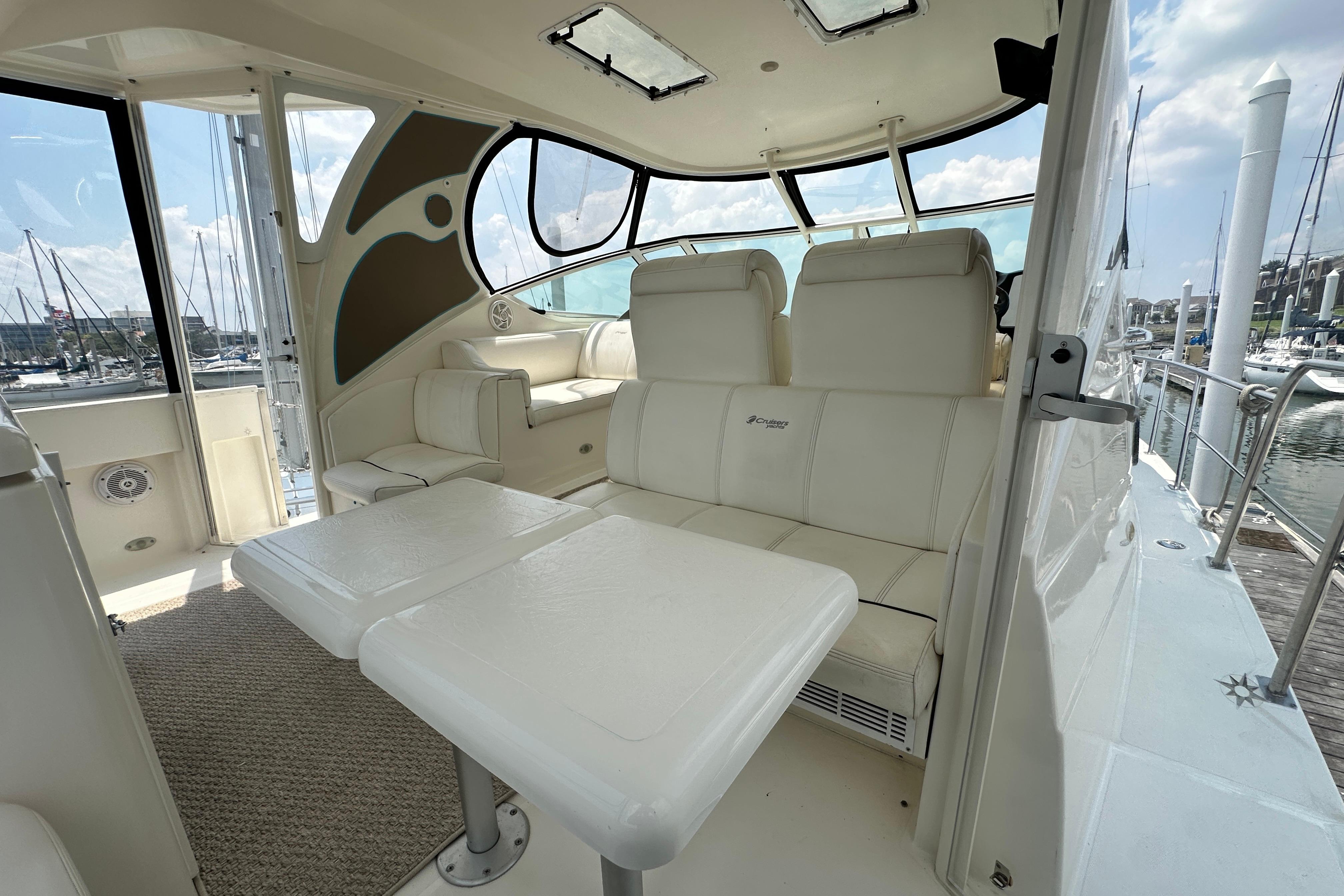 2004 Cruisers Yachts 405 Express Motoryacht interior with white seating and table, docked at marina.