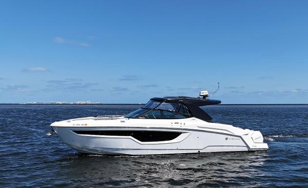 2020 Cruisers Yachts 38 GLS OB on open water under clear blue sky.