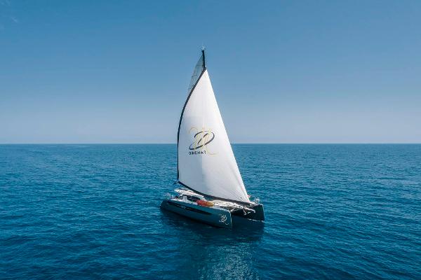 Sailing catamaran Privilege Signature 580, 2025 model, gliding on open sea under clear blue sky.