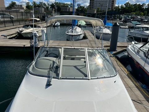 A 1997 Bayliner 2566 Ciera docked in a marina, surrounded by other boats.