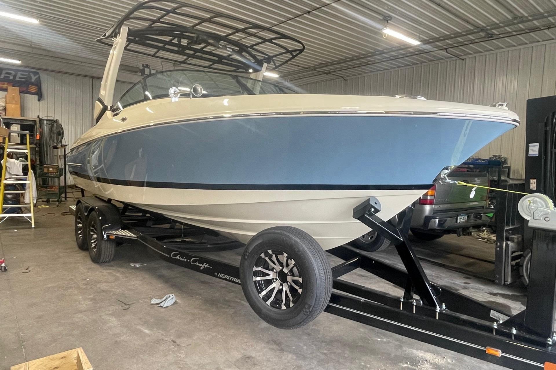 2026 Chris-Craft Sportster 25 boat in a garage on trailer.