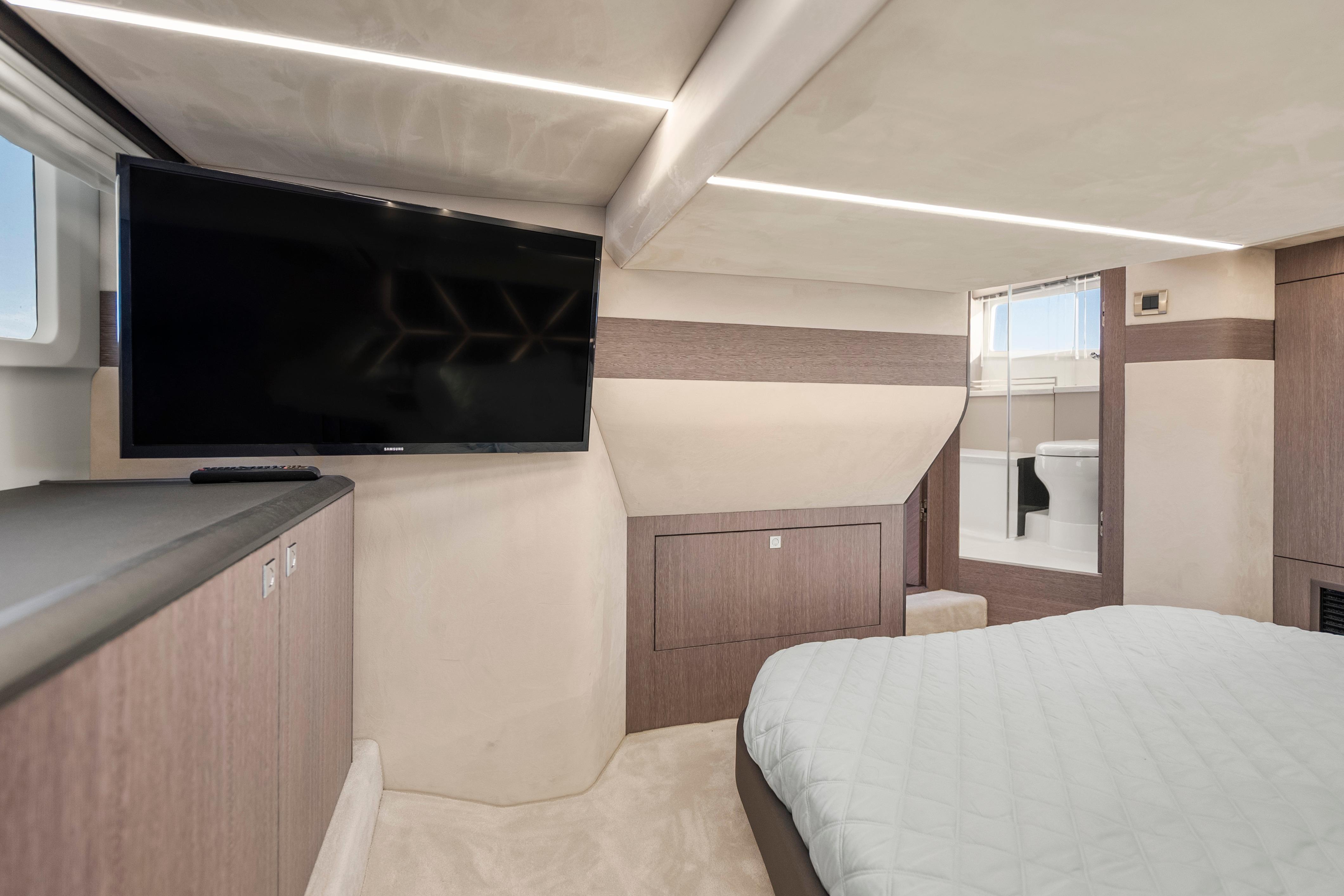 Luxurious interior of 2023 Galeon 400 Fly yacht with TV and ensuite bathroom.