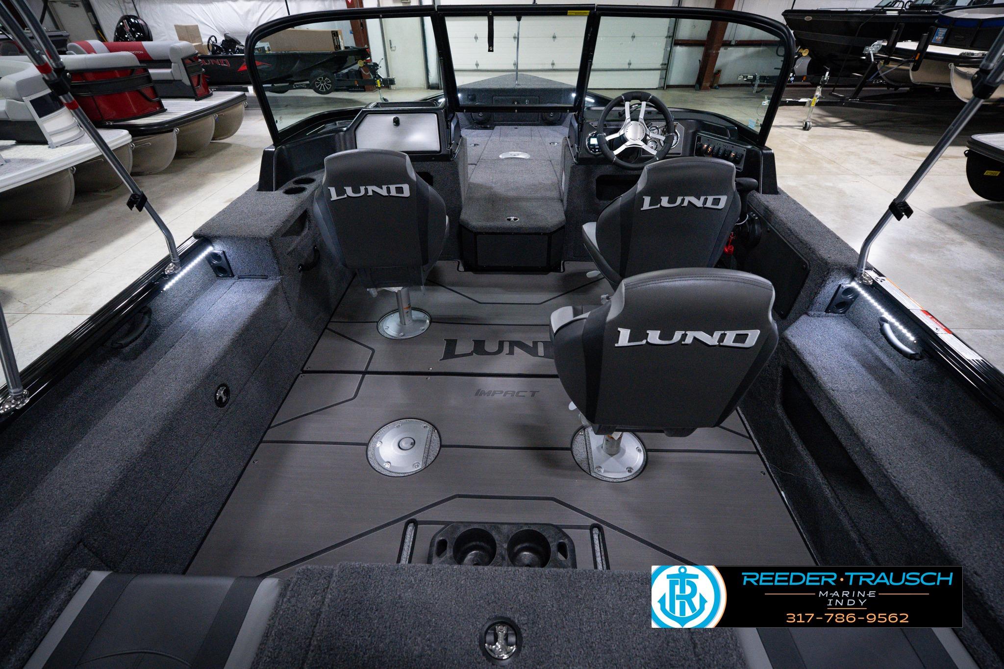 2026 Lund 1875 Impact XS SS boat interior with seating and steering wheel in showroom.
