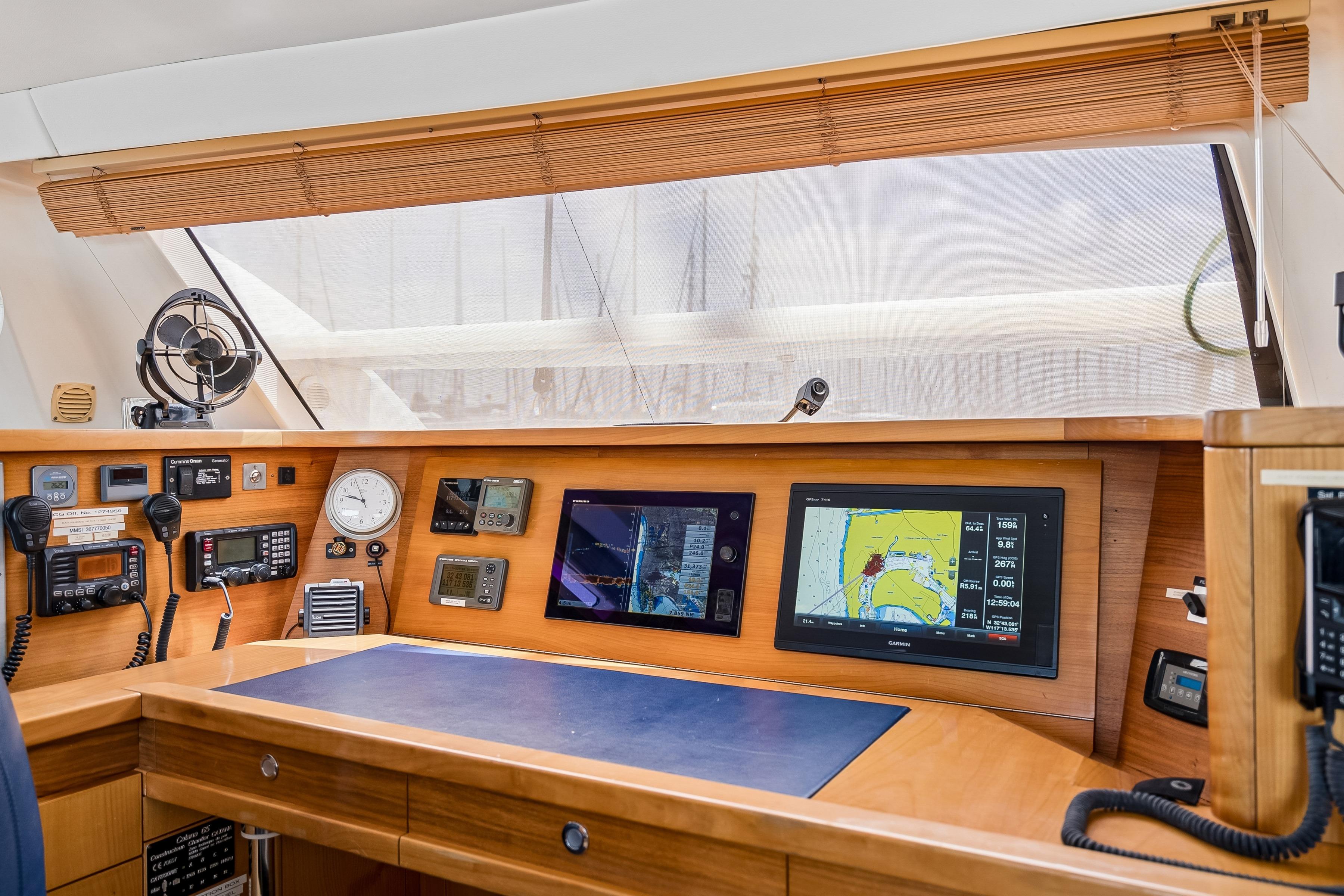 Navigation station of 2009 Catana 65 yacht with advanced electronic equipment and wooden finish.