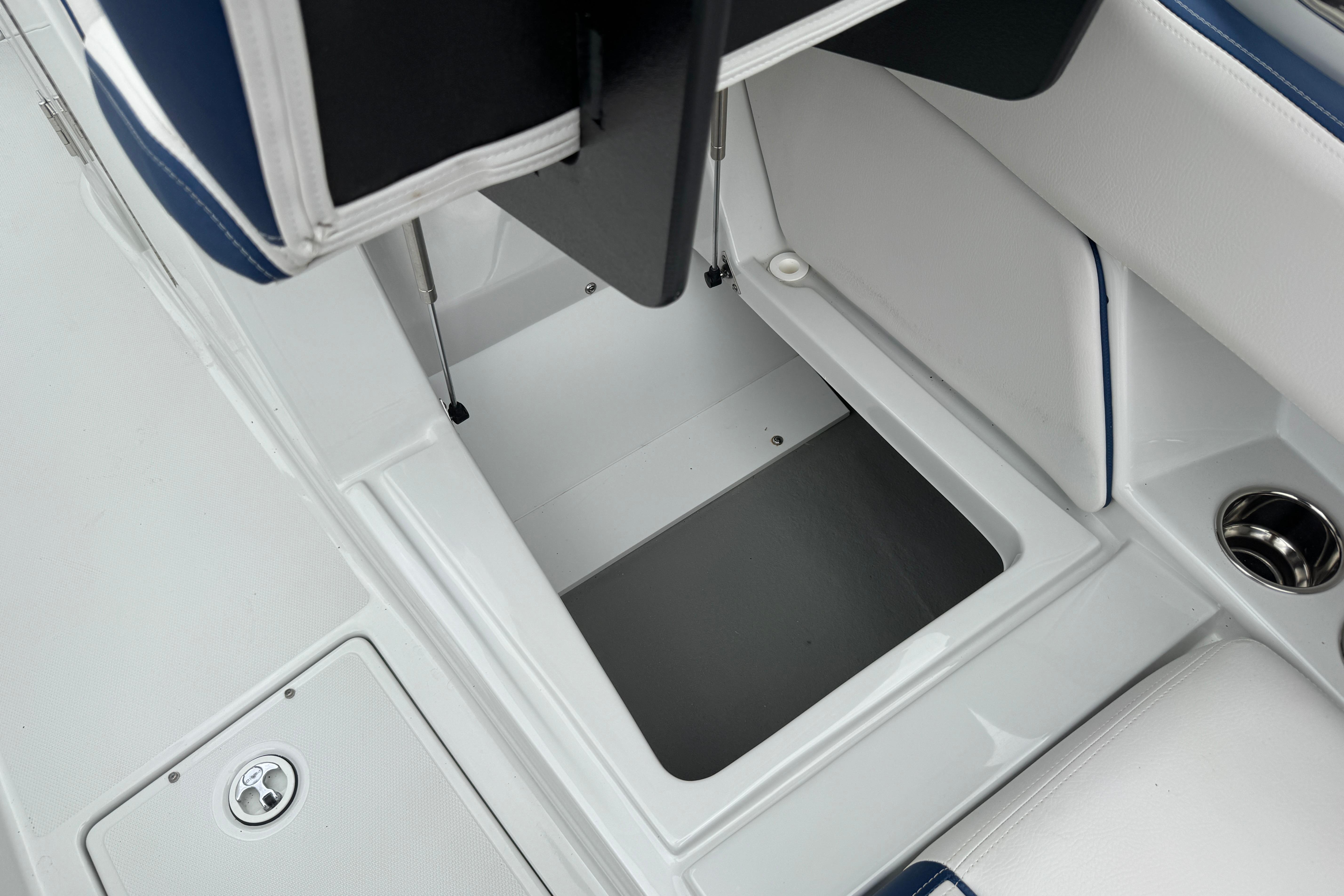 Storage compartment on 2025 Crownline 290 XSS boat, featuring sleek white and blue interior design.