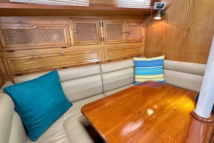 Cozy 1978 Rival 41C sailboat interior with wooden cabinets and cushioned seating.