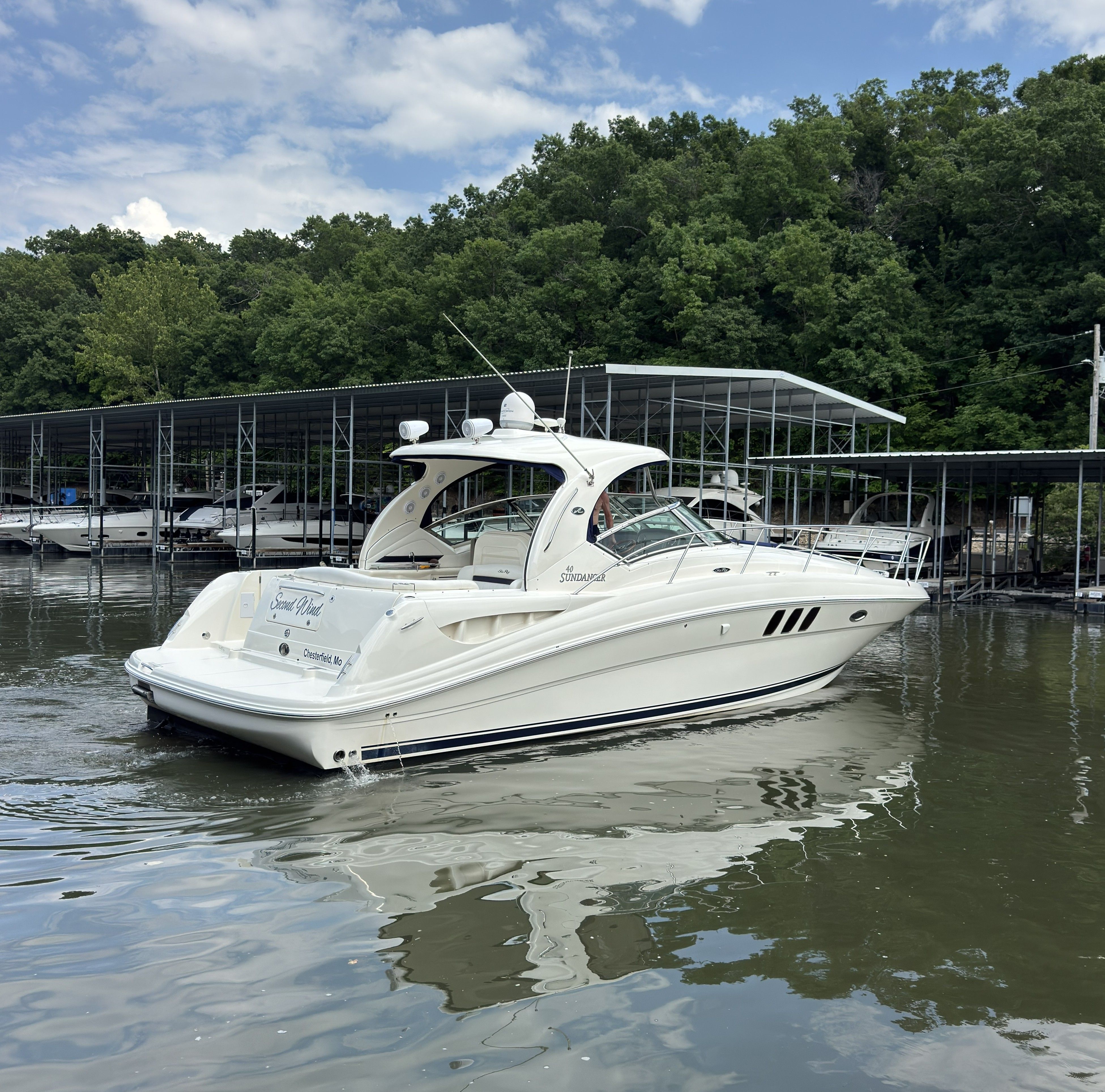 A 2007 Sea Ray 40 Sundancer on calm water, surrounded by trees and boat docks.