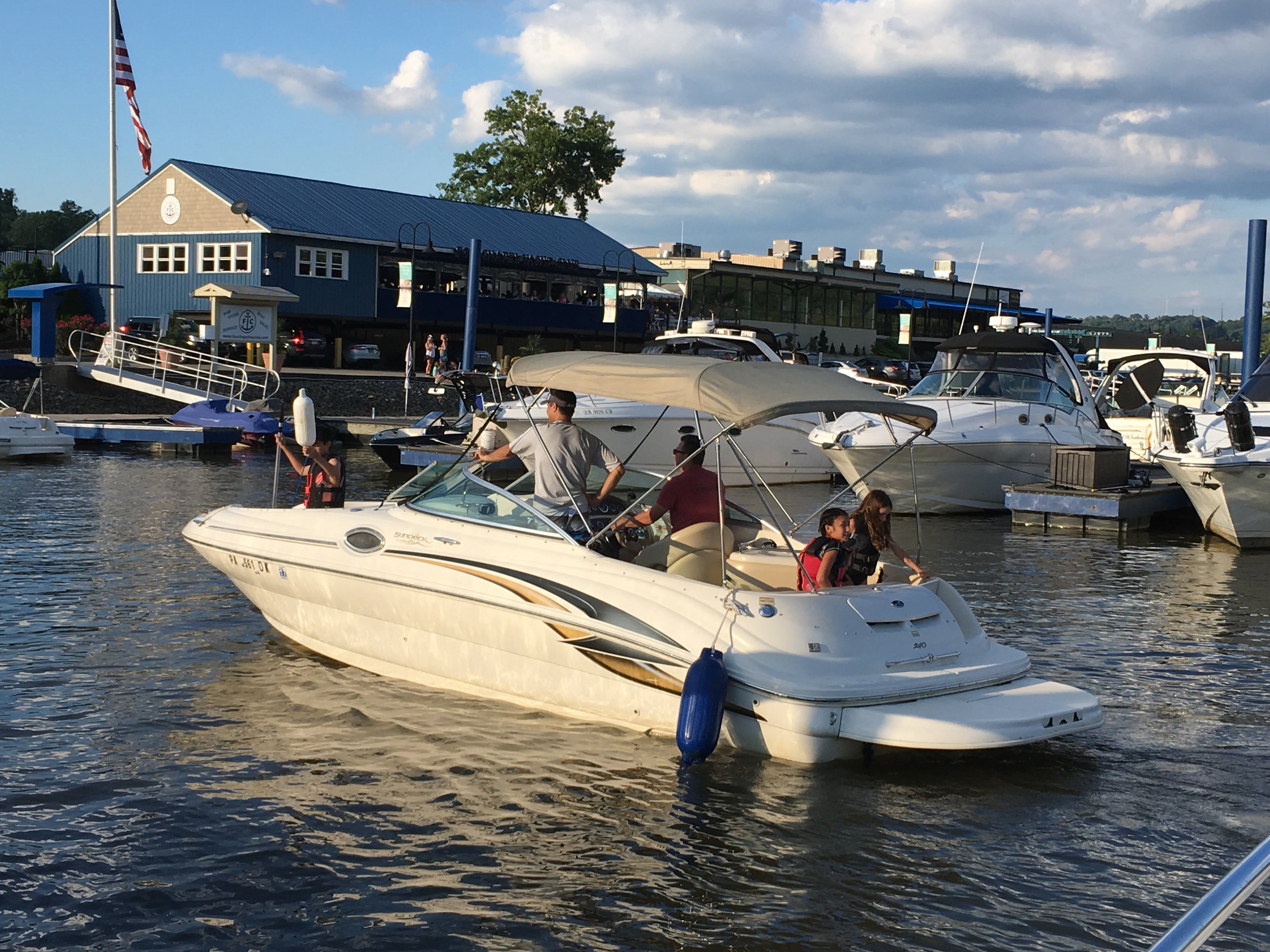 Sea Ray 240 Sundeck 2001 boat in harbor with passengers.