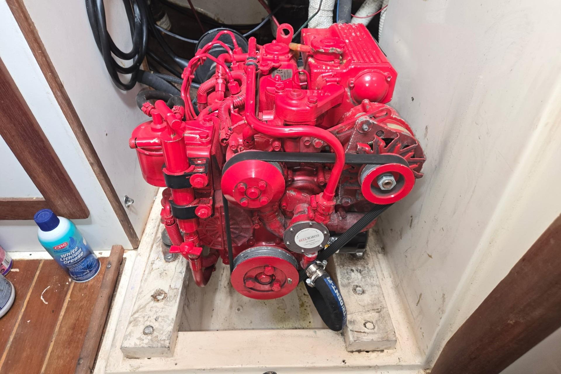 Red engine inside a 1981 Sea Sprite 34 sailboat, showcasing detailed mechanical components.