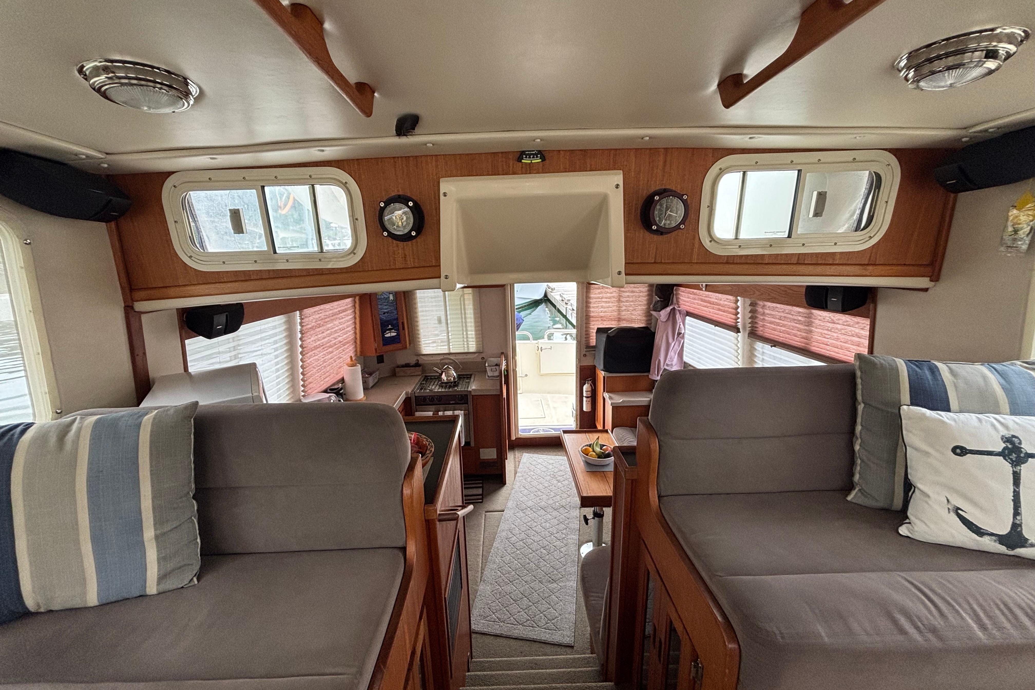 Interior of a 2004 Nordic Tug 37, featuring cozy seating and a compact kitchen area.