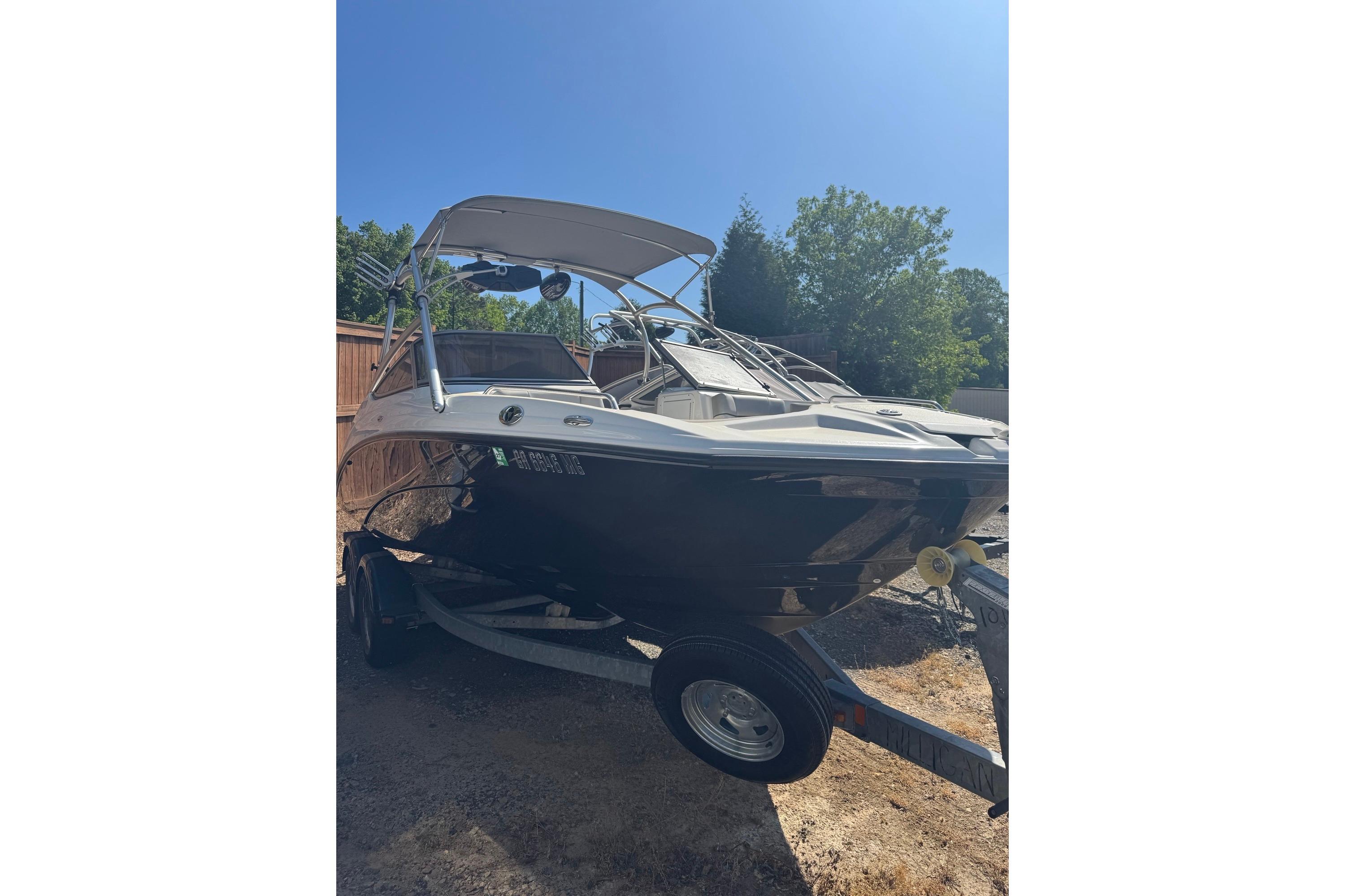 2012 Yamaha Boats AR210 on trailer, parked outdoors under clear blue sky.