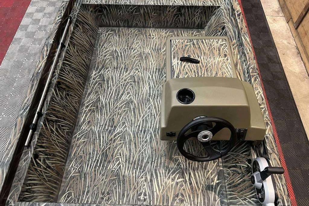 2026 Tracker Grizzly 1648 SC boat interior with camouflage design and steering console.
