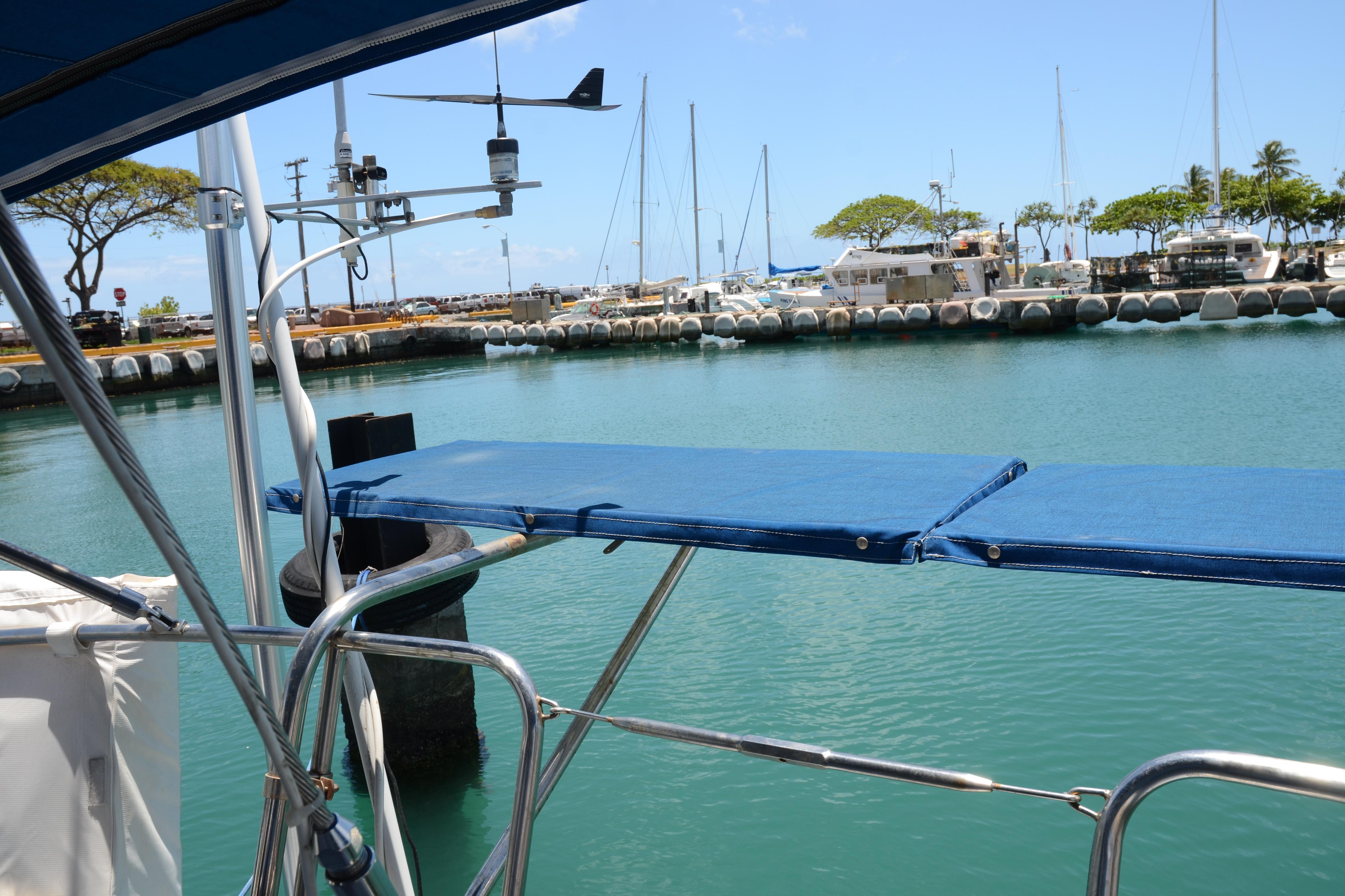 Sailboat docked in marina, Norseman 400, 1987 model, calm waters, clear sky.