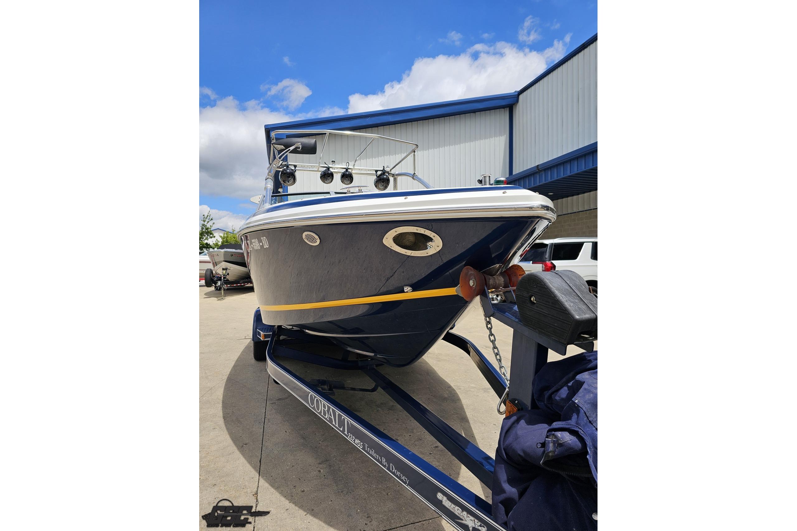 2010 Cobalt 232 WSS boat on trailer, parked outdoors under blue sky.