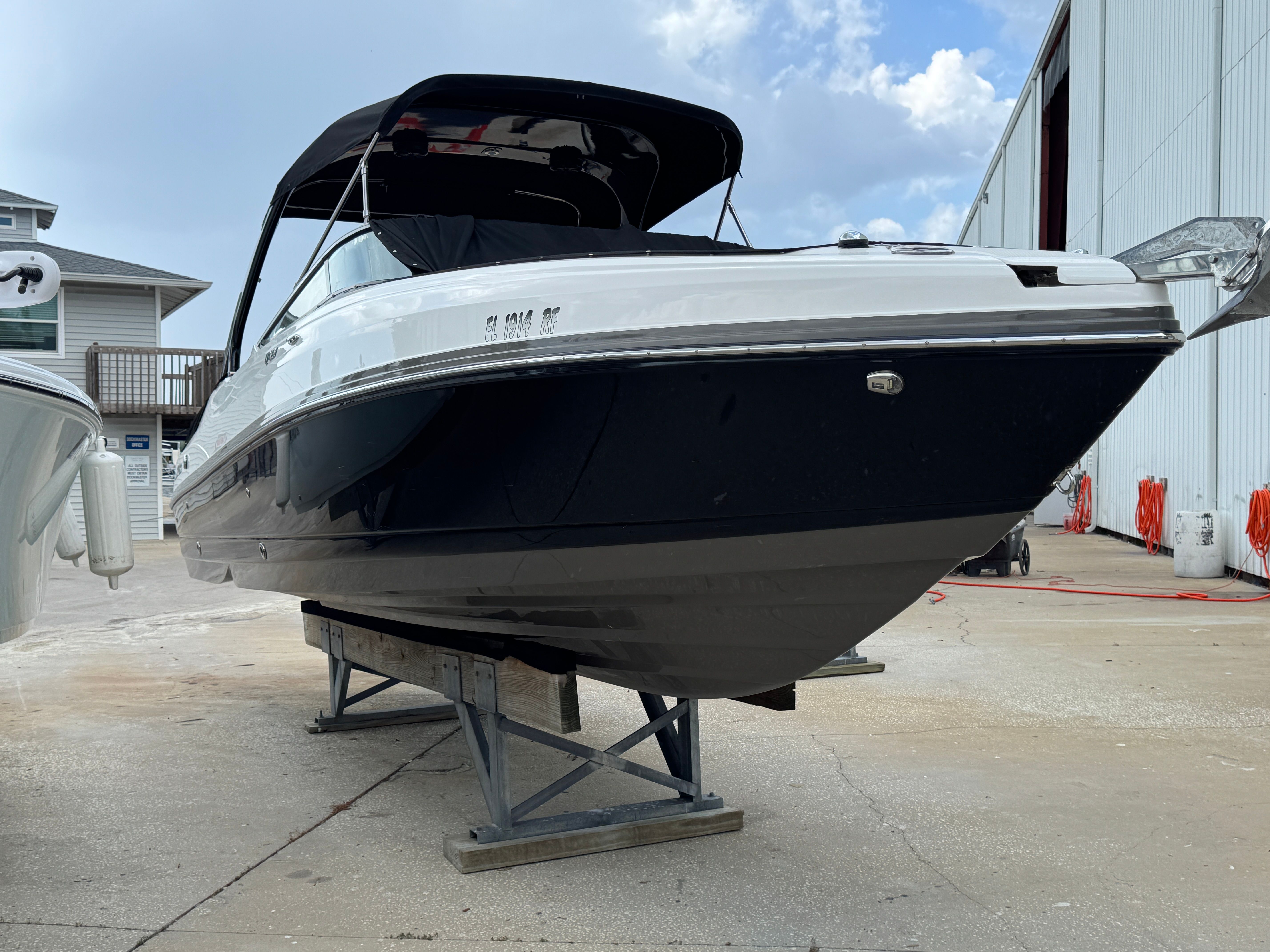 2017 Rinker QX29 BR boat on a stand outdoors.
