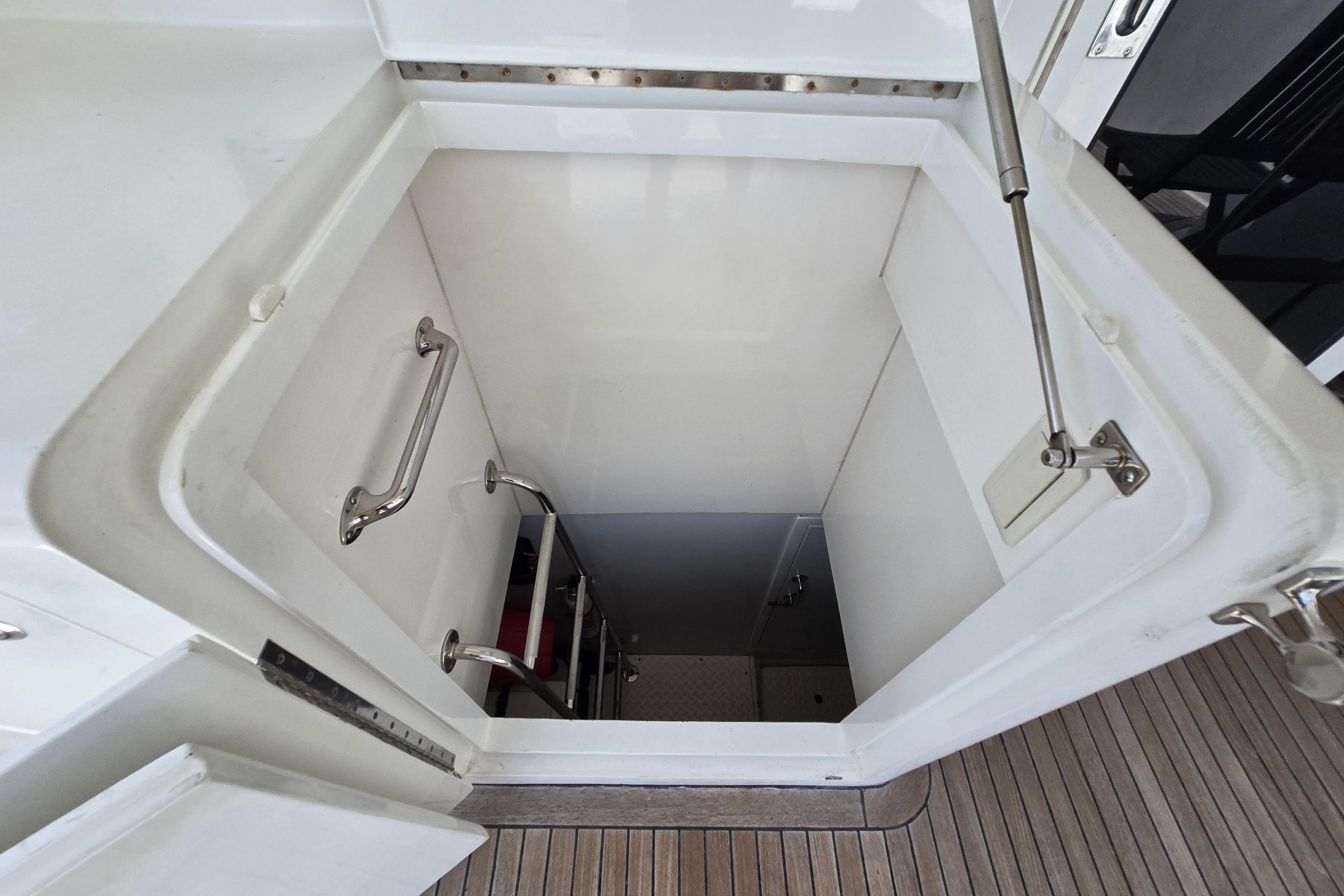 Hatch entrance with ladder on 2004 Grand Harbour 58 yacht, featuring stainless steel handles.