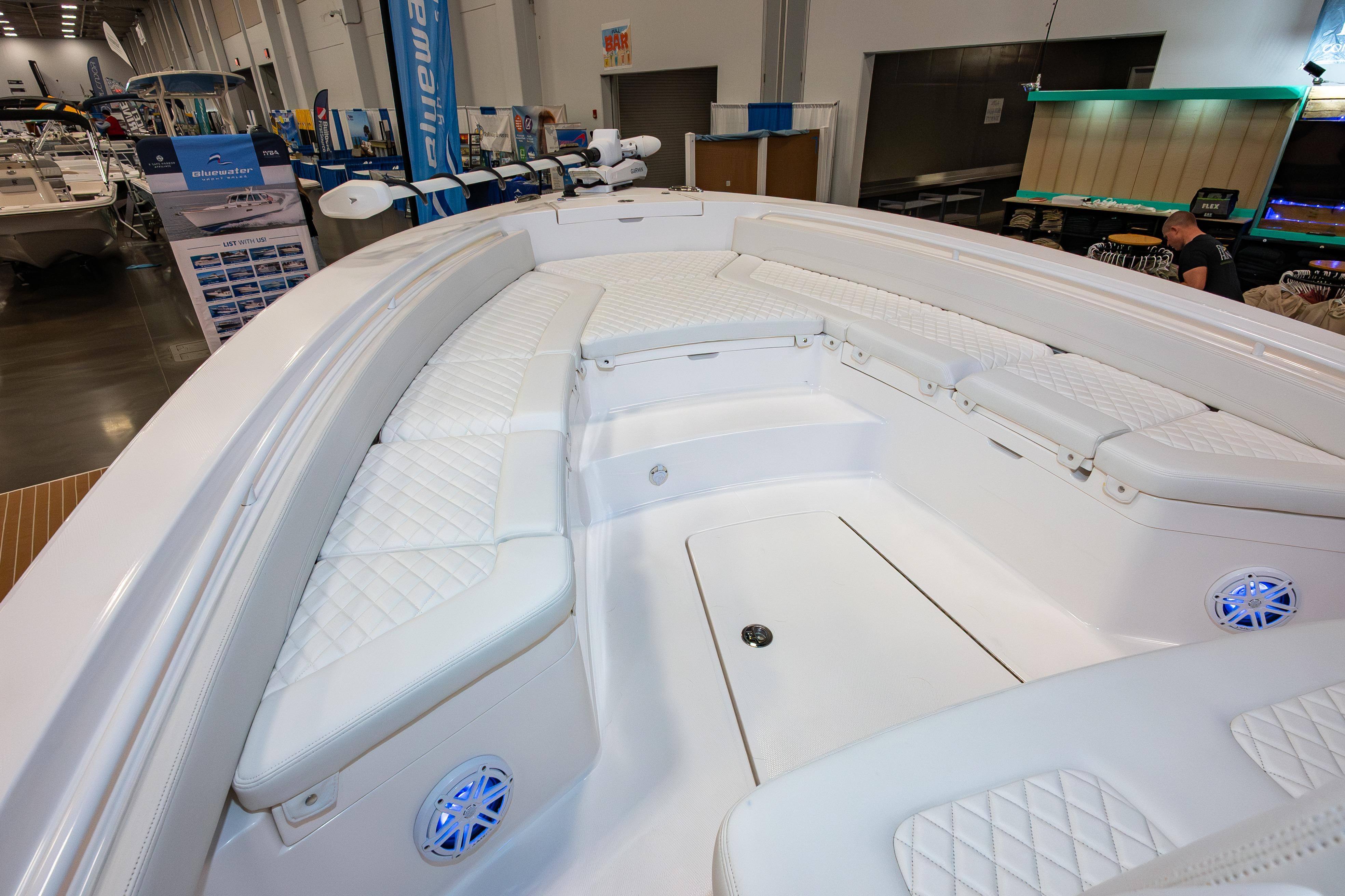 2025 Regulator 26XO boat interior with white cushioned seating at a boat show.