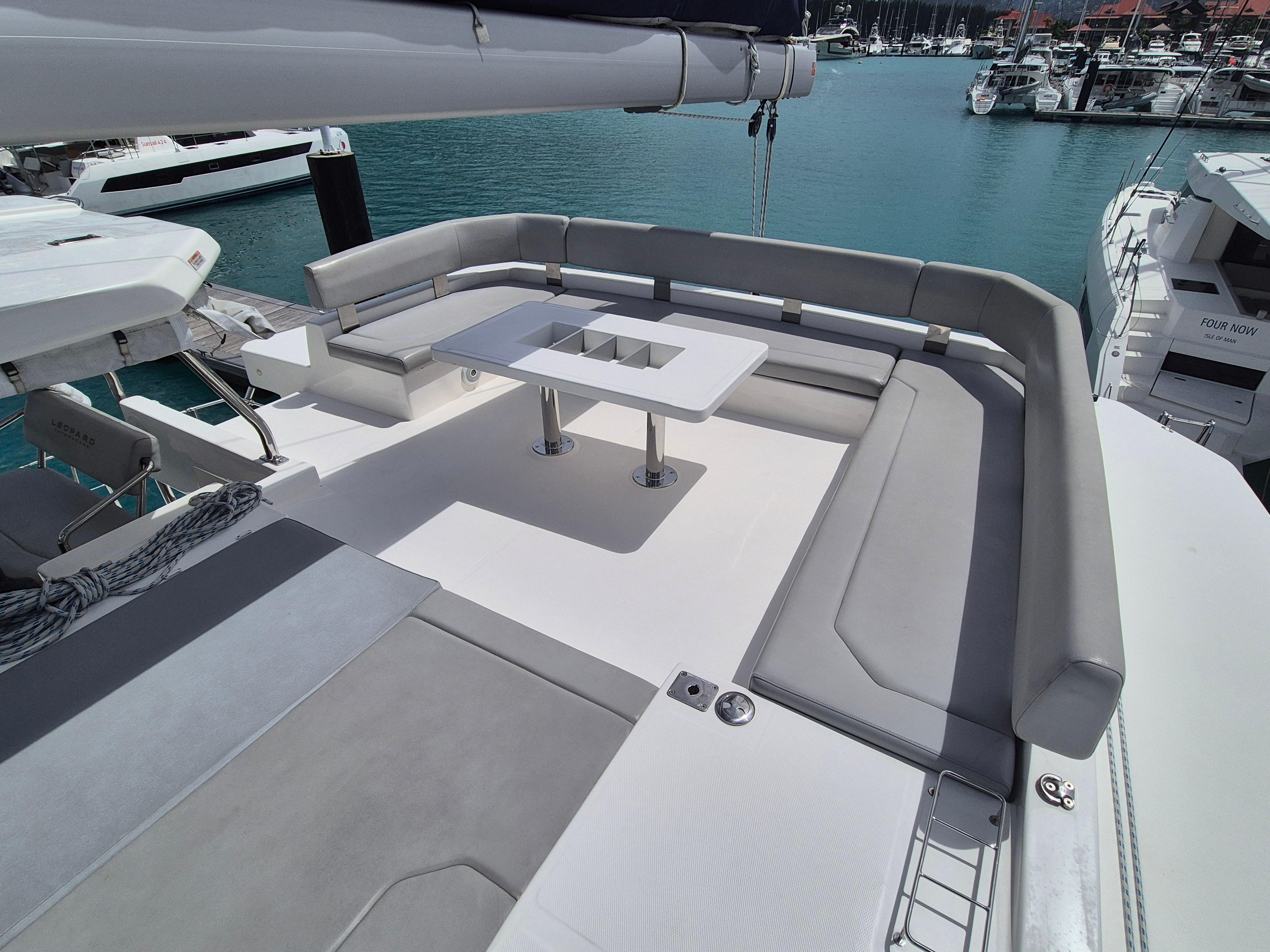 Luxurious seating area on a 2020 Leopard 50 yacht, docked at a marina.