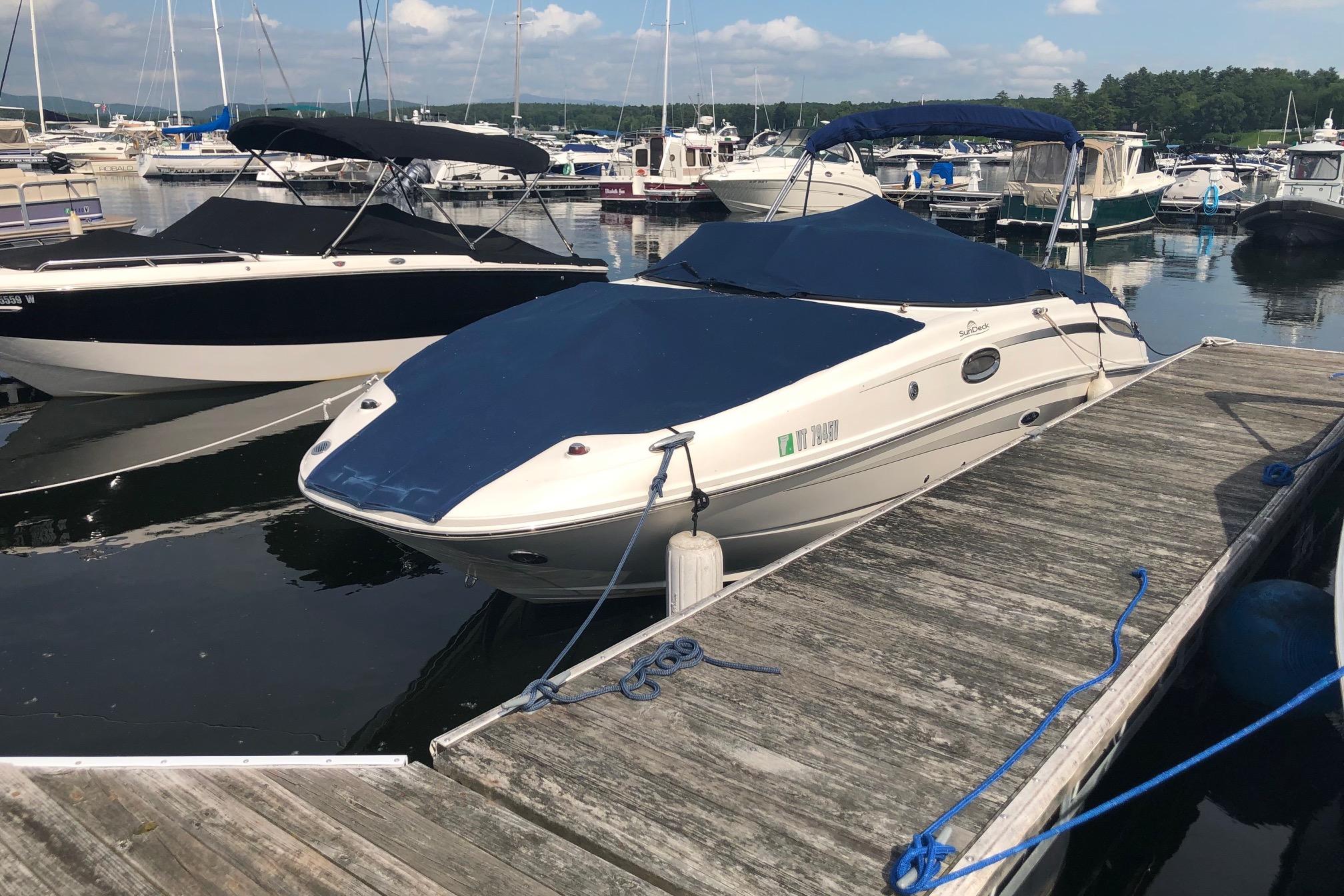2013 Sea Ray 260 Sundeck boat docked at a marina with blue cover.