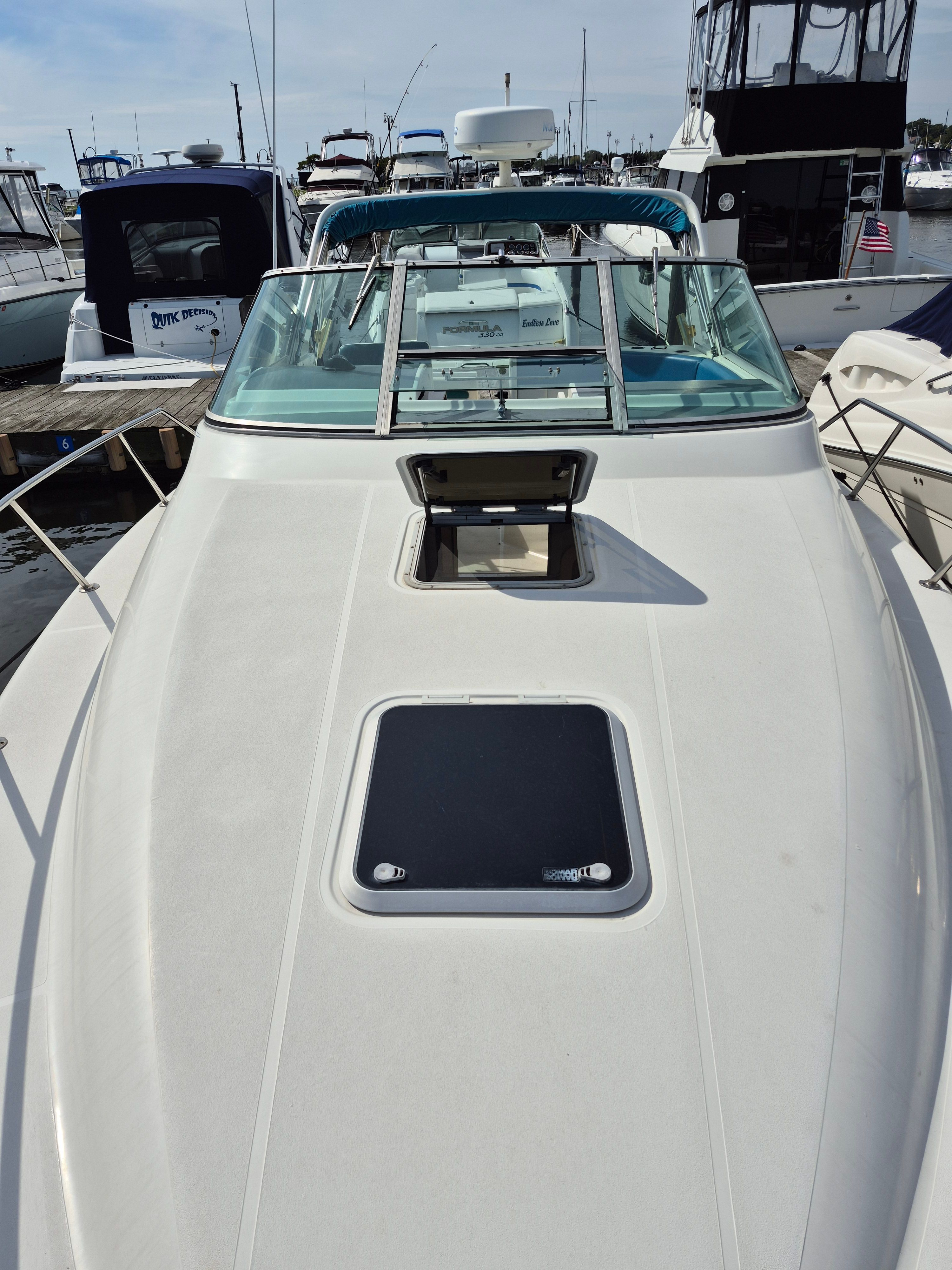 A 1989 Tiara Yachts Slickcraft with a white deck and blue windows, docked in a marina.