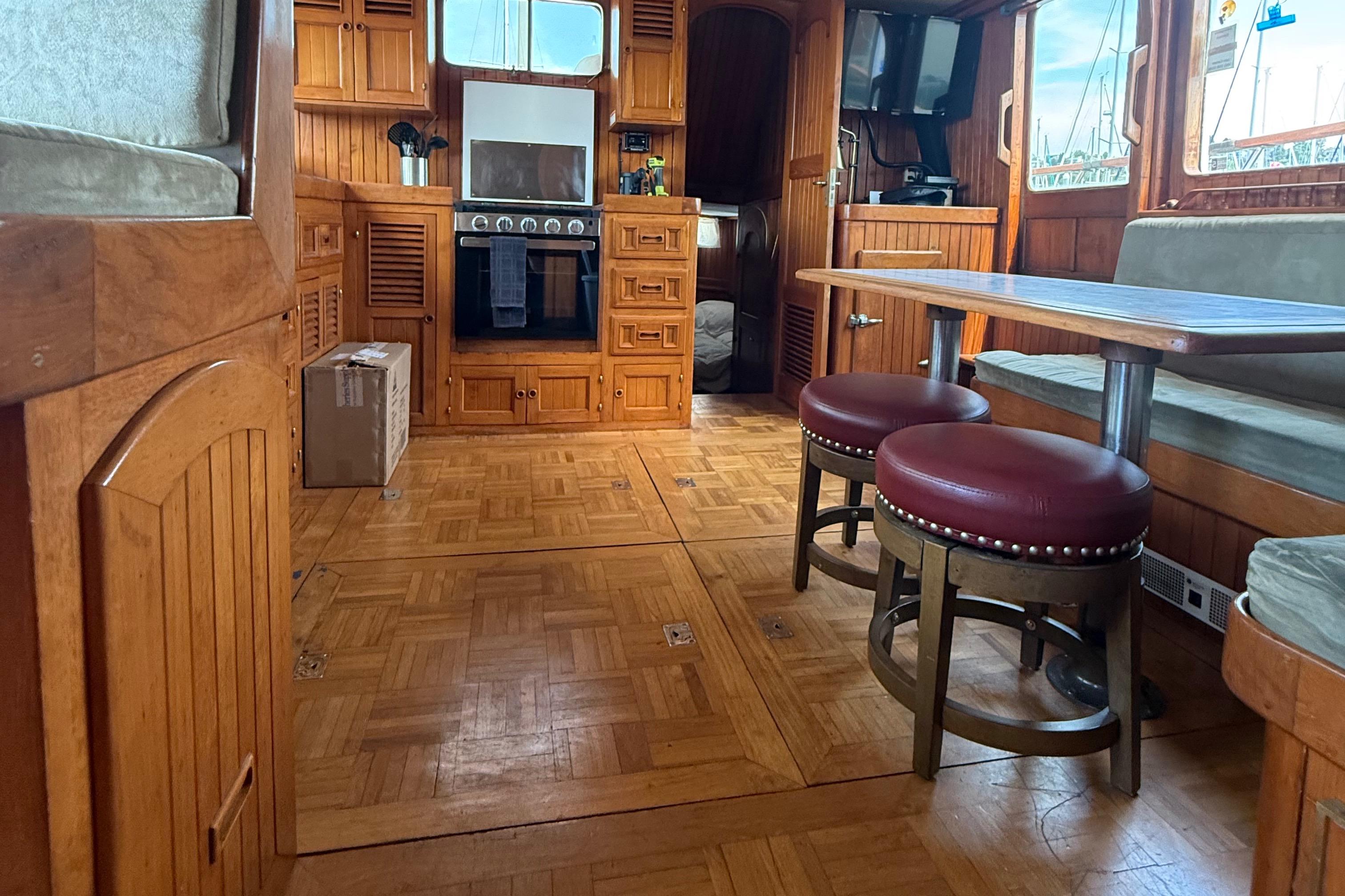Interior of 1978 DeFever 39 yacht with wooden cabinetry and dining area.