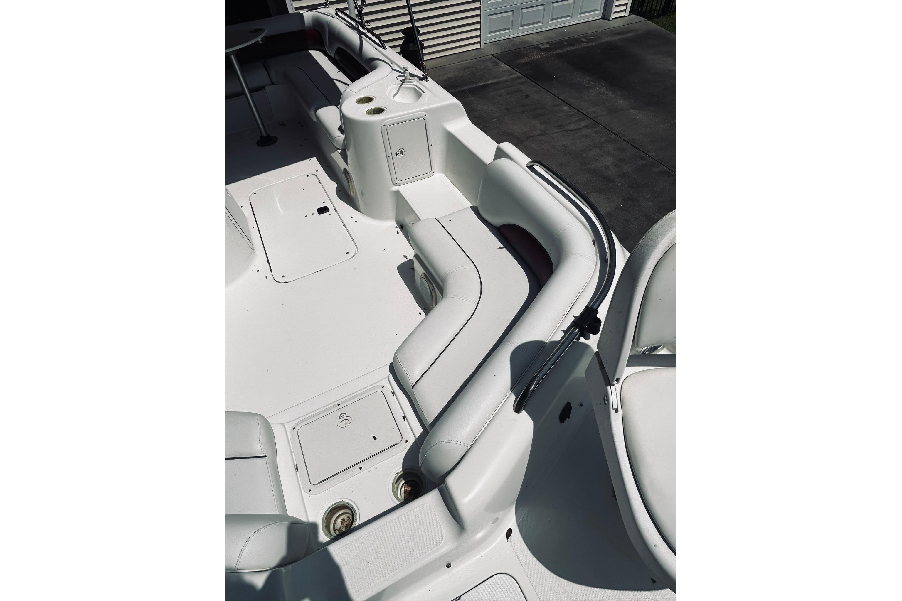 2013 Hurricane SunDeck Sport 201 OB boat interior with white seating and storage compartments.