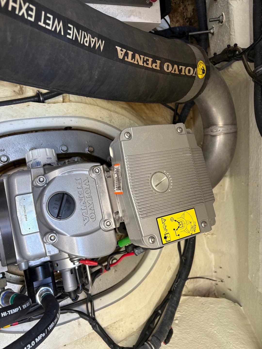 Engine room of a boat with Volvo Penta engine and exhaust system.