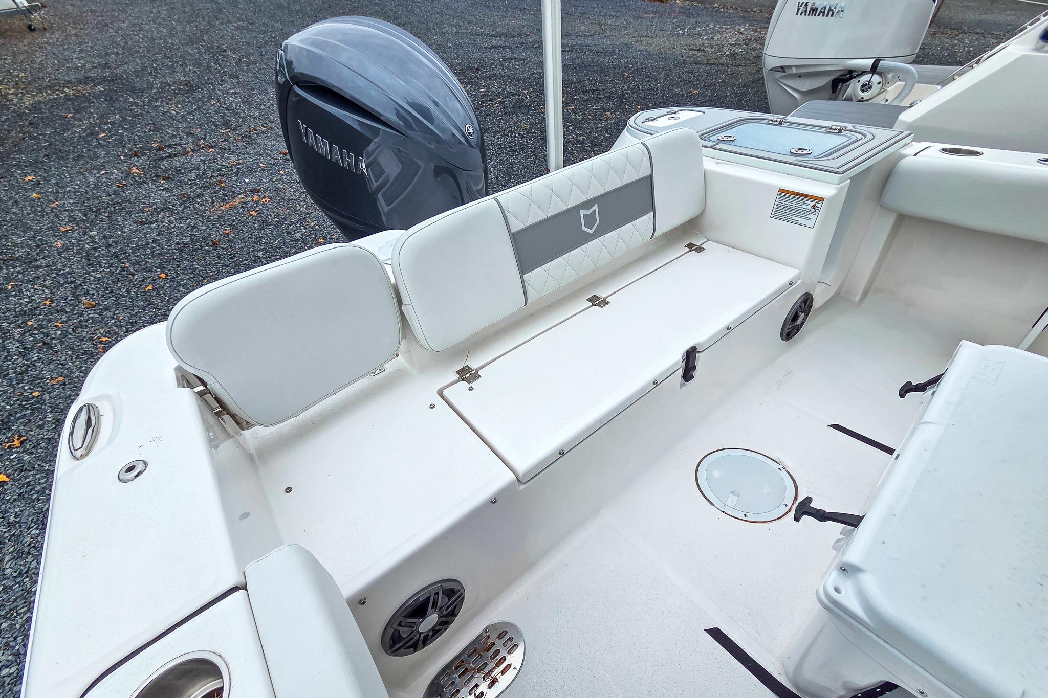 2026 Sea Fox 228 Commander boat interior with Yamaha engine, featuring white seating and storage.