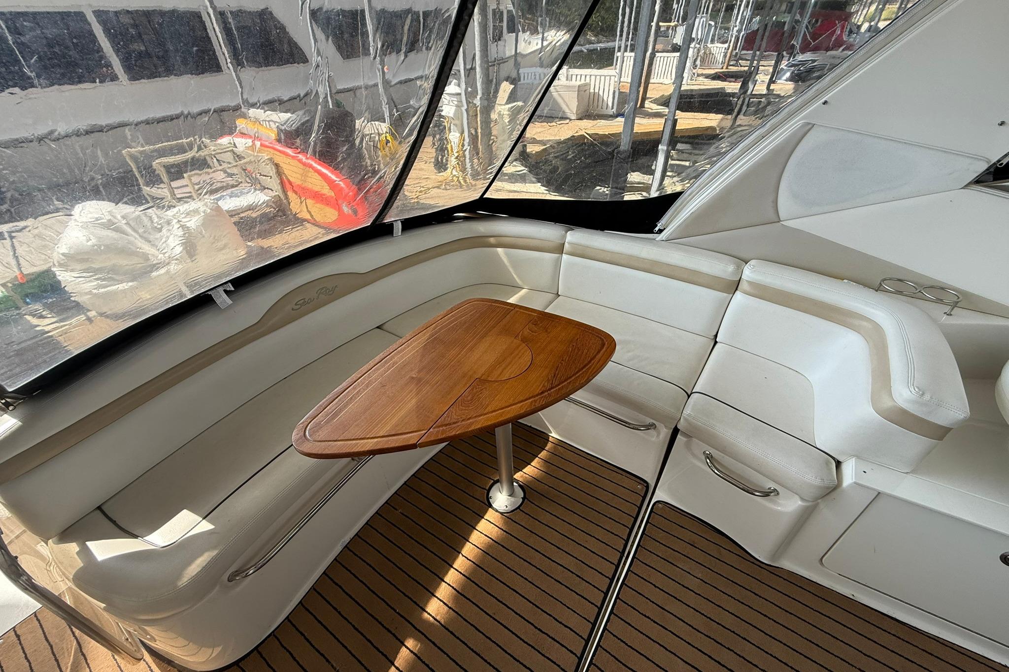 Interior of 2009 Sea Ray 350 Sundancer with wooden table and white seating.
