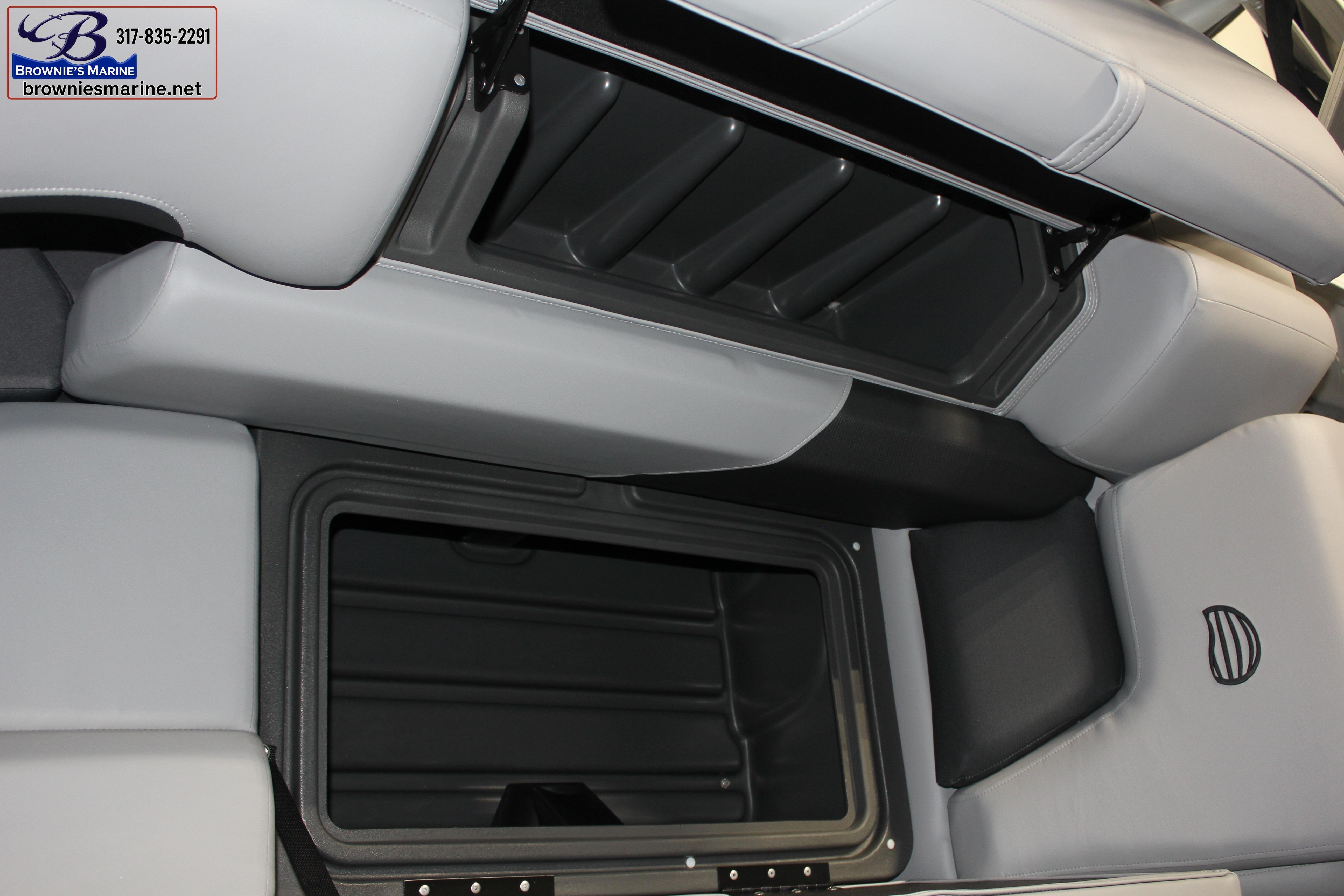 2026 Sun Tracker Party Barge 22 DLX interior storage compartment with cushioned seating.