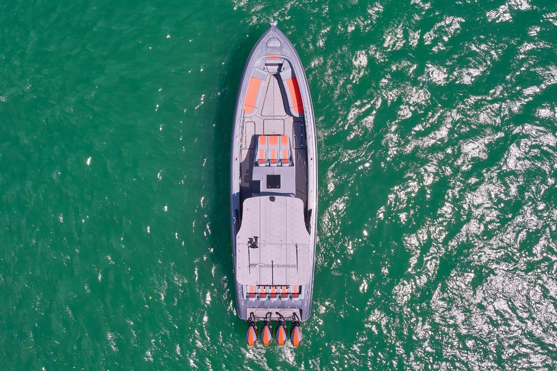 Aerial view of 2022 Midnight Express 43 Open boat on vibrant green water.