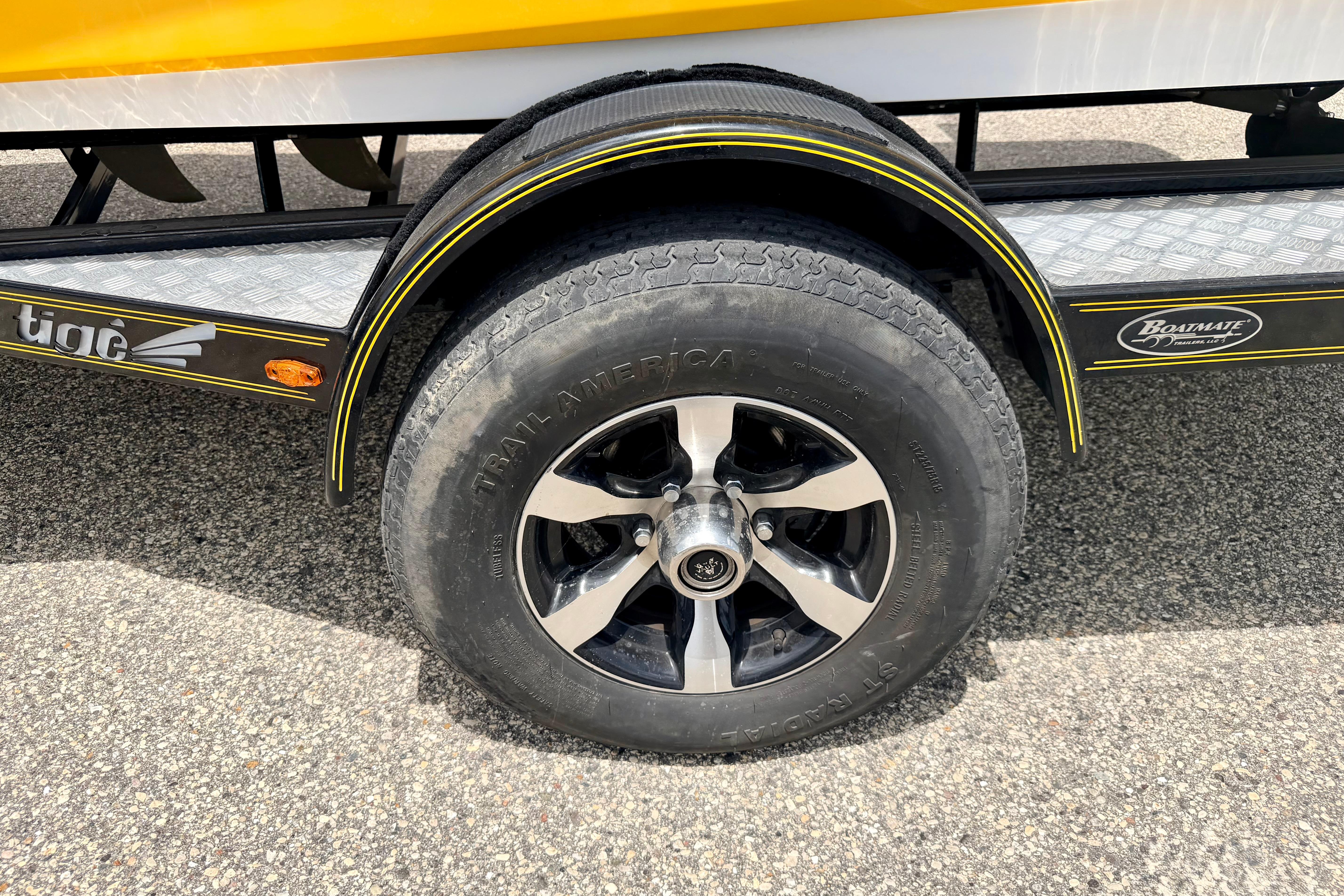 Trailer wheel of 2014 Tigé R20 boat with black and silver rim.