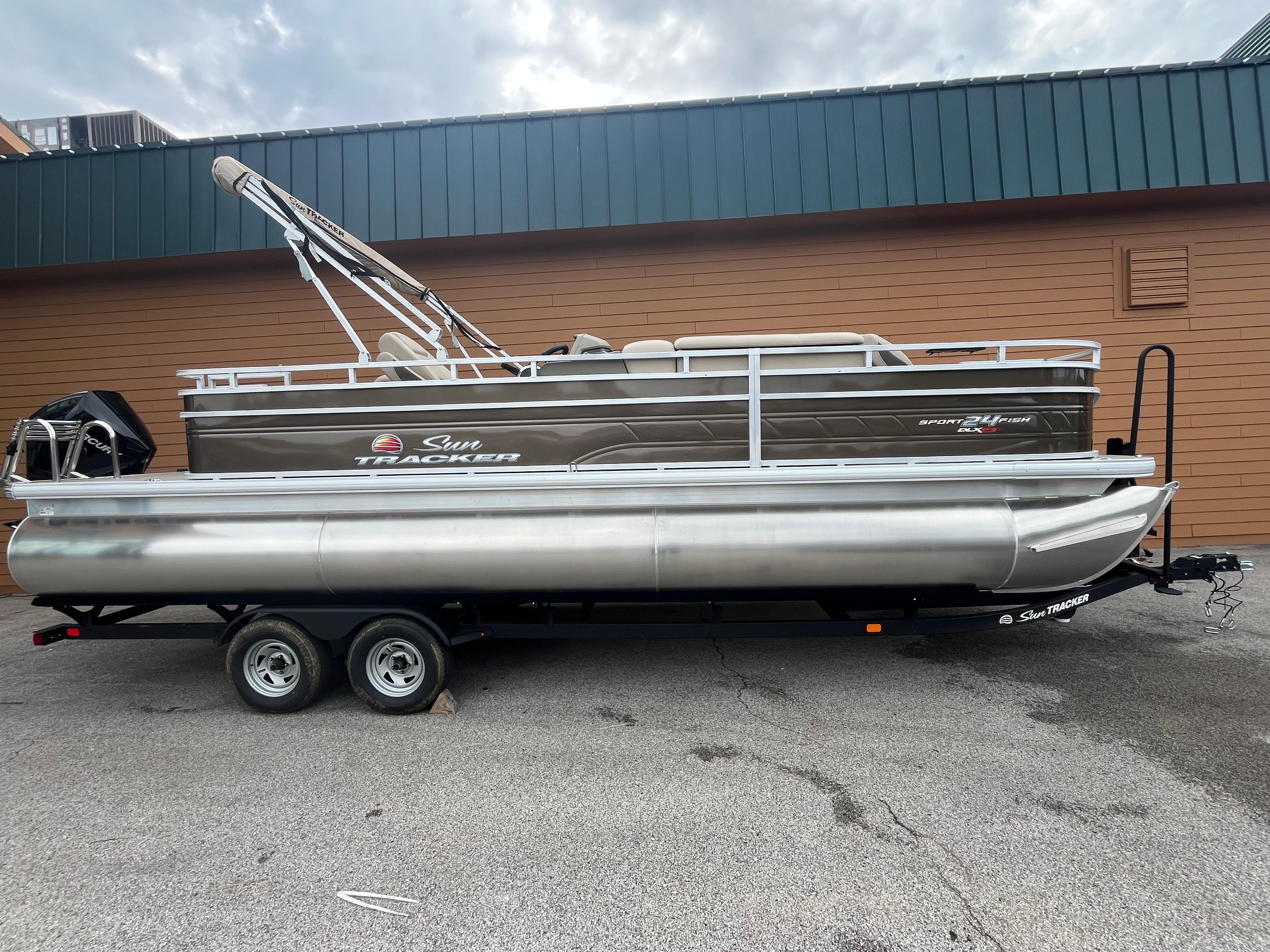 2025 Sun Tracker Sportfish 24 XP3 pontoon boat on trailer, parked outdoors.