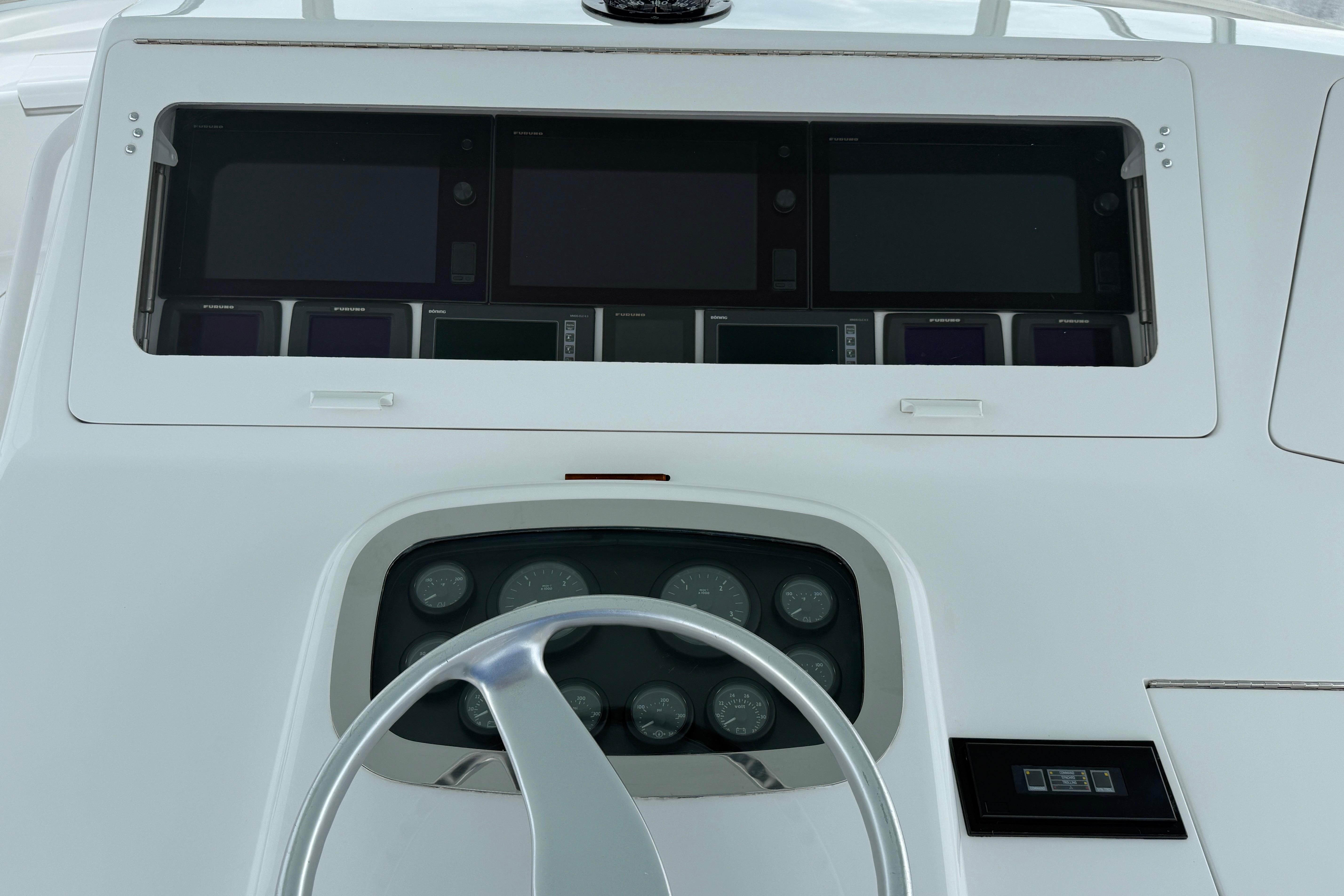 Helm of 2000 Viking 55 Convertible yacht with navigation instruments and steering wheel.