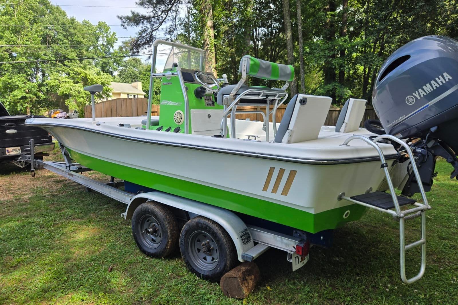2016 Epic 21 Sport Console boat on trailer with Yamaha engine in a wooded area.
