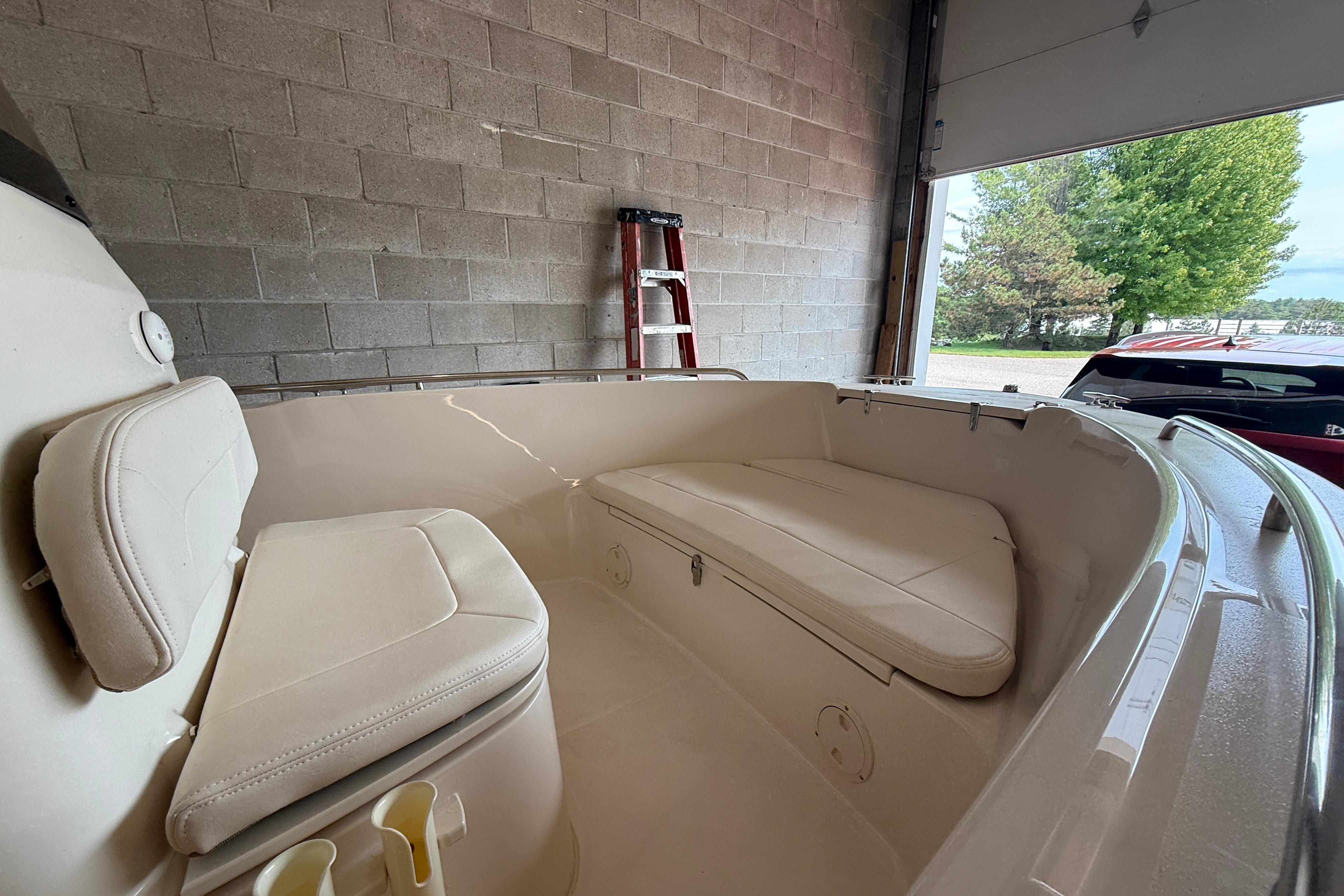 2025 Grady-White Fisherman 180 boat interior with cushioned seating in a garage setting.