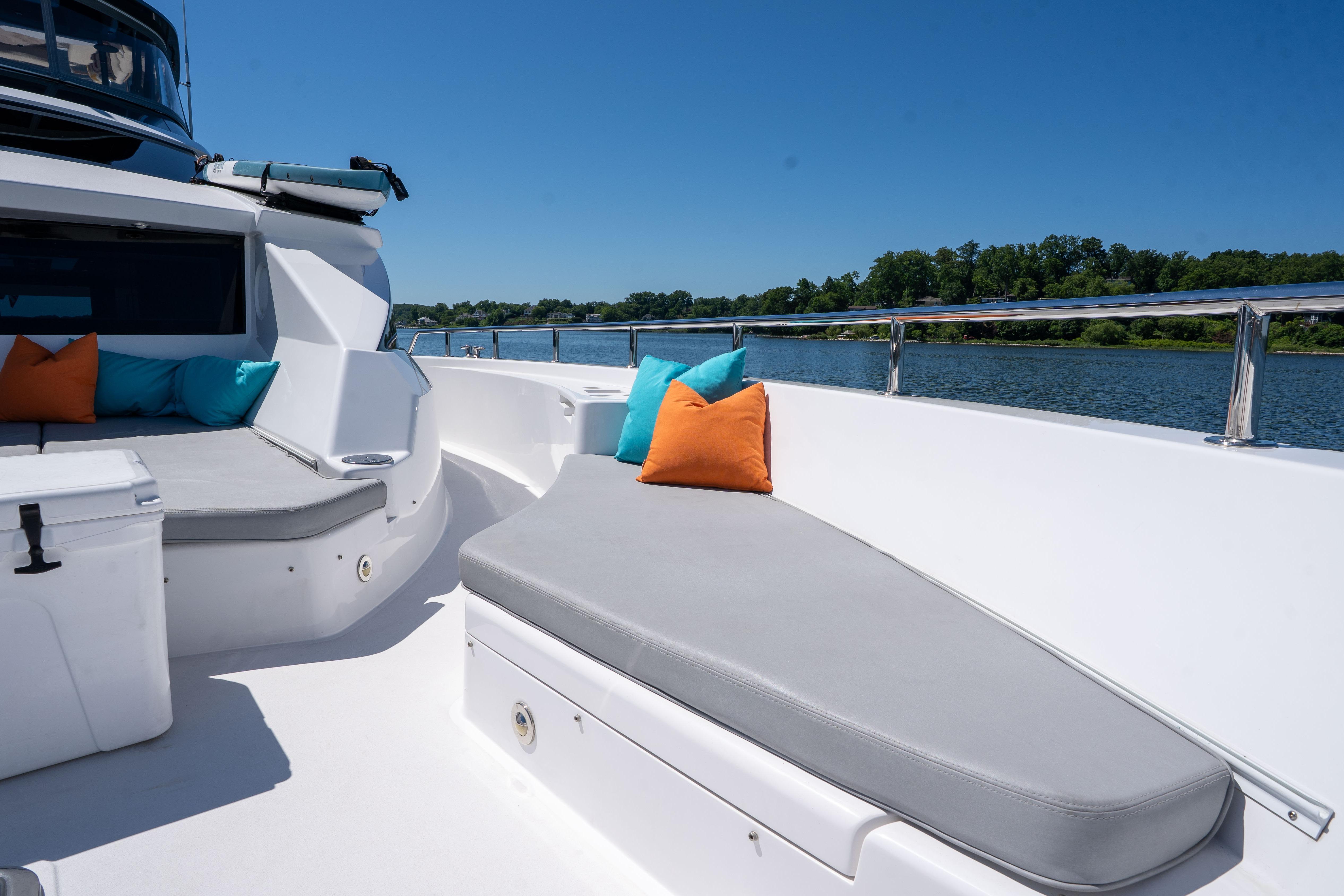 Luxurious 2021 Hatteras M75 Panacera yacht deck with cushions and scenic water view.