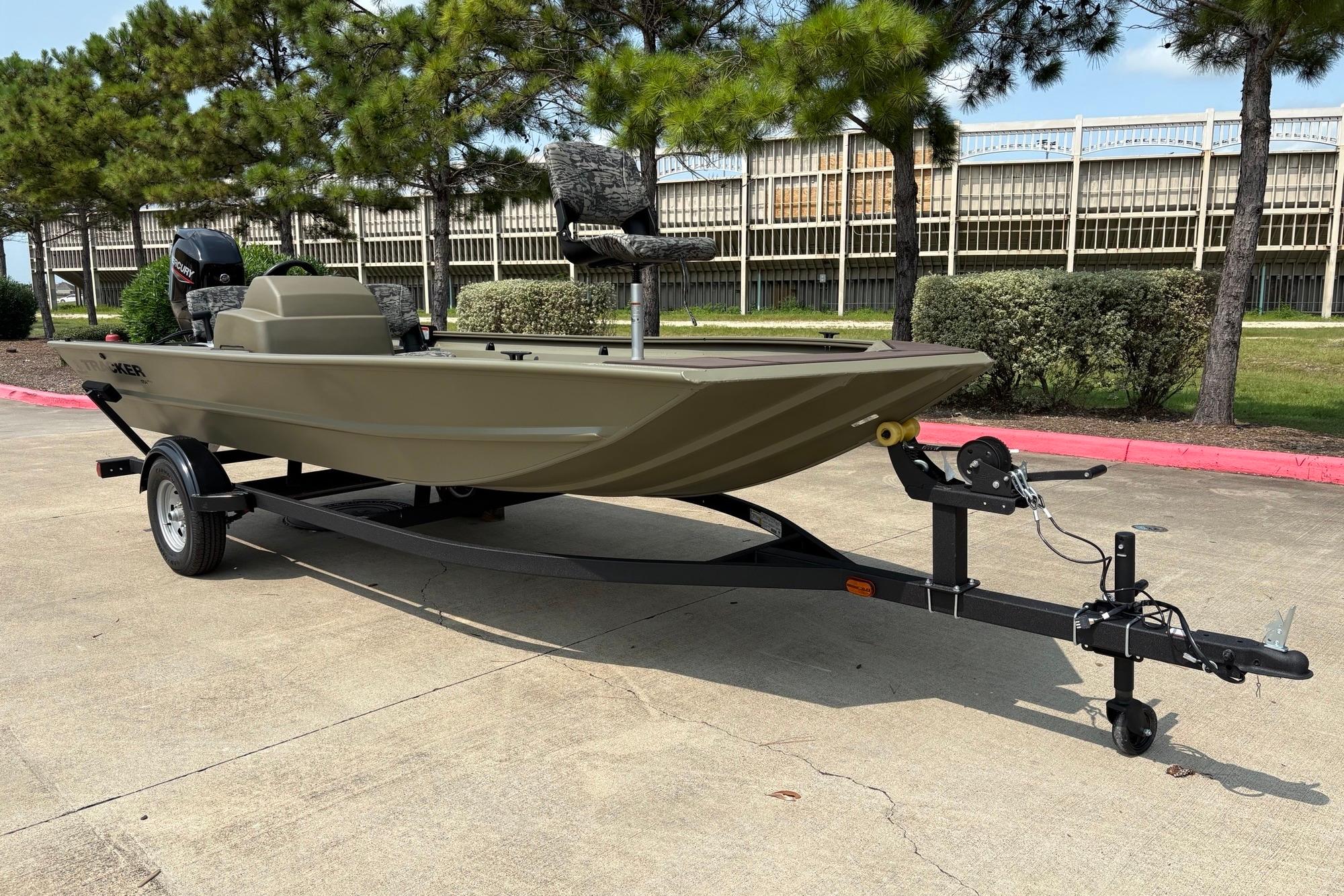 2026 Tracker Grizzly 1754 SC boat on trailer, parked outdoors near trees.
