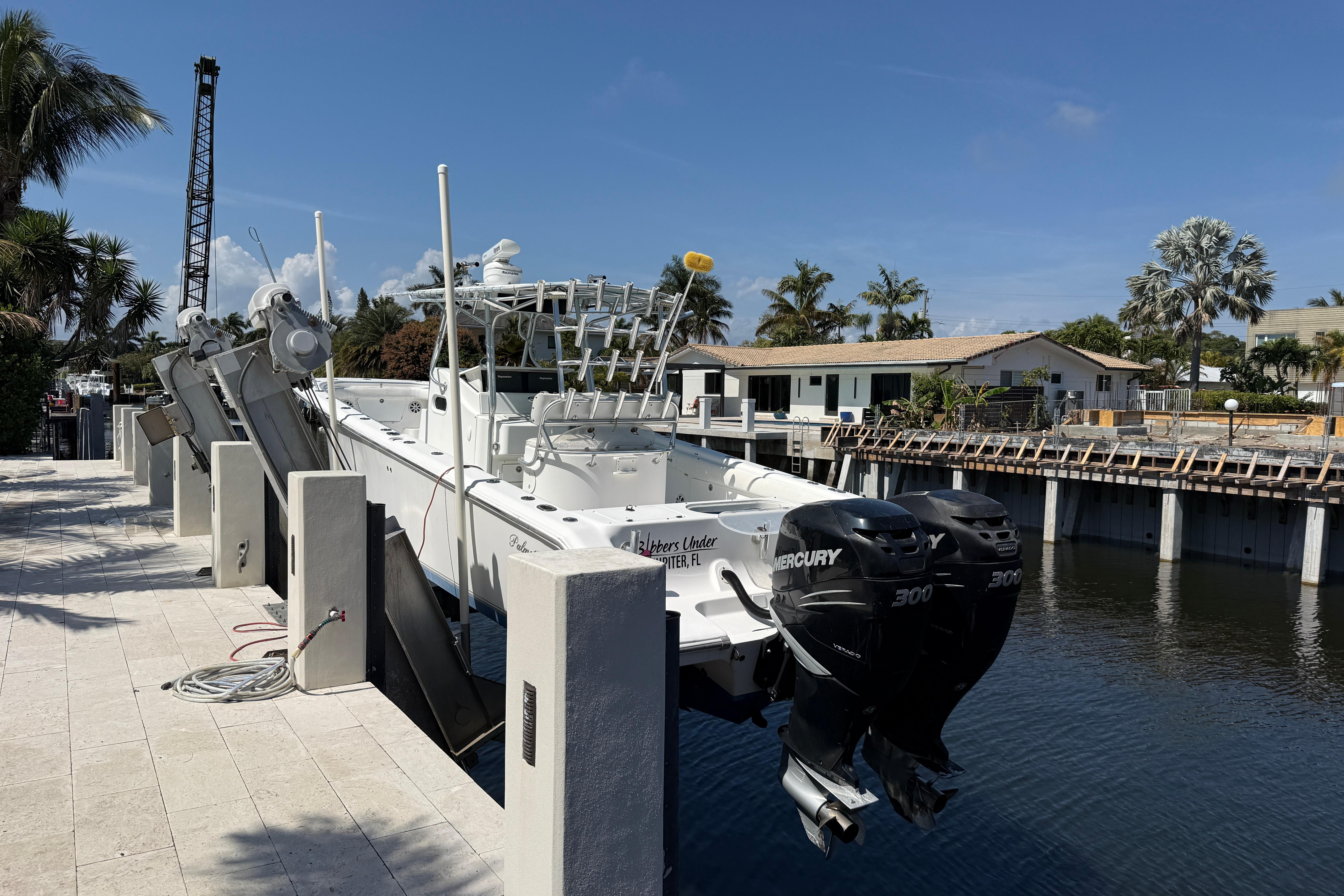 2003 Palmetto 33 Adventure boat docked with dual Mercury engines, surrounded by tropical scenery.
