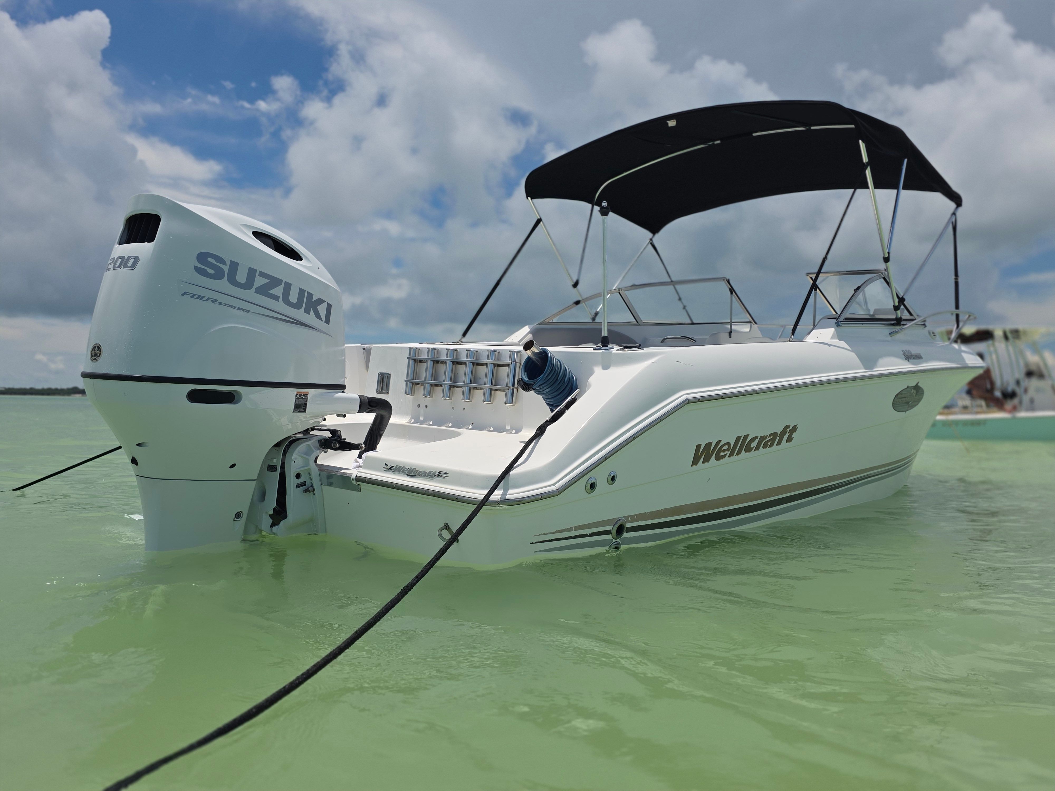 Wellcraft Sportsman 2001 boat on water with Suzuki engine.