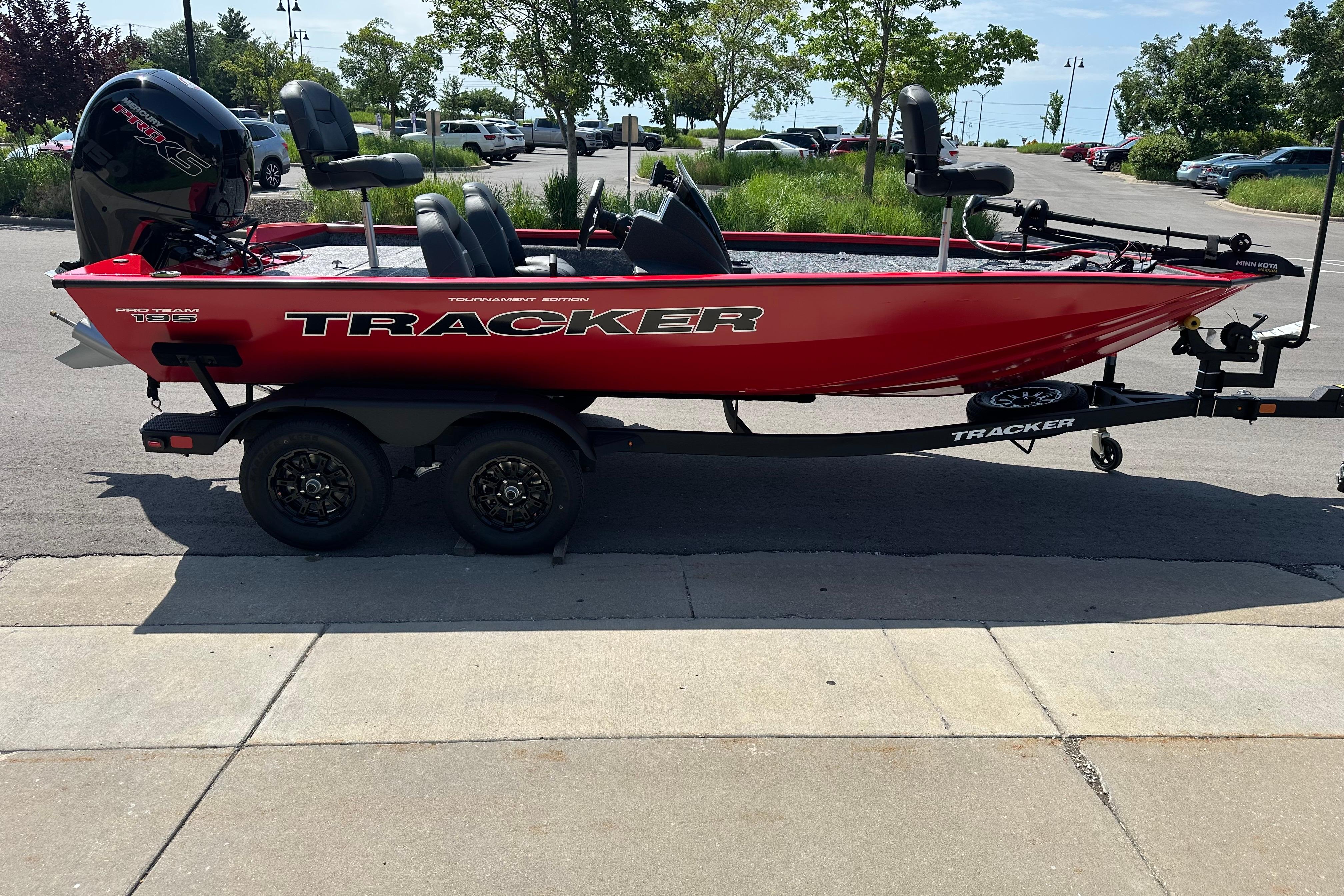 2026 Tracker Pro Team 195 boat on trailer, vibrant red, parked outdoors.