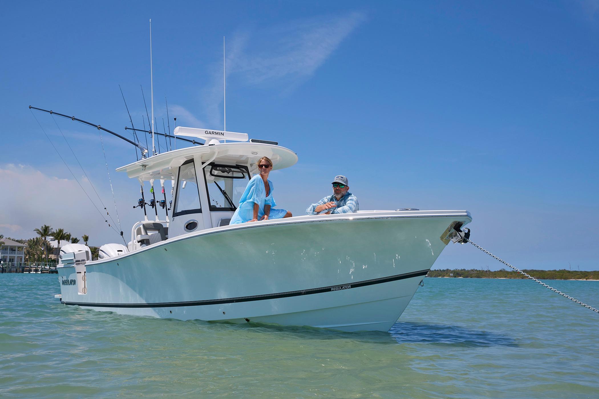 2025 Regulator 31 boat anchored in clear water with two people onboard.