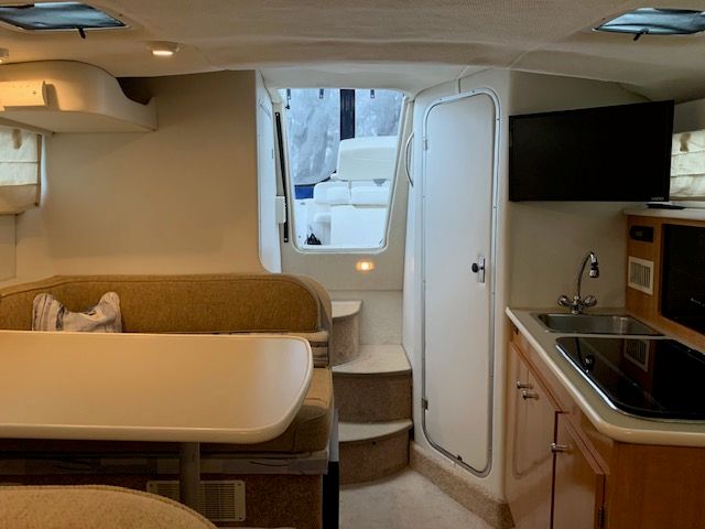 Interior of a 2002 Bayliner 2855 with kitchen and seating area.