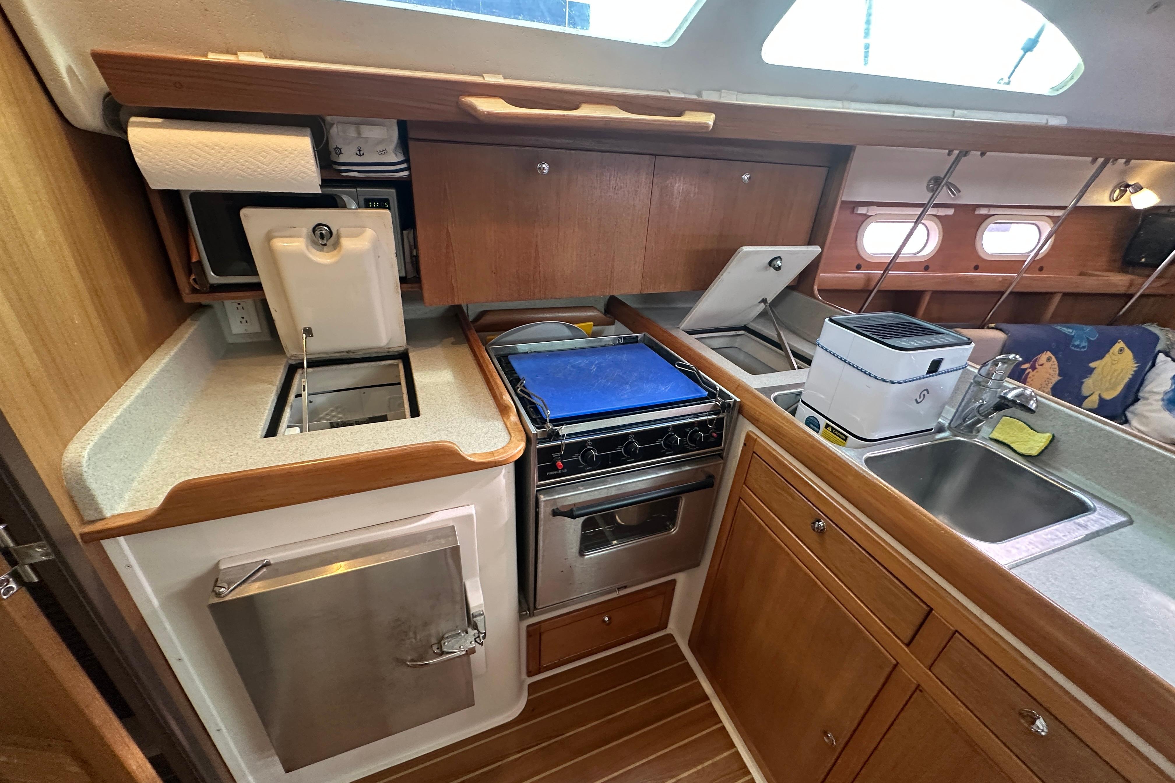 2006 Catalina 387 yacht kitchen with stove, sink, and wooden cabinetry.