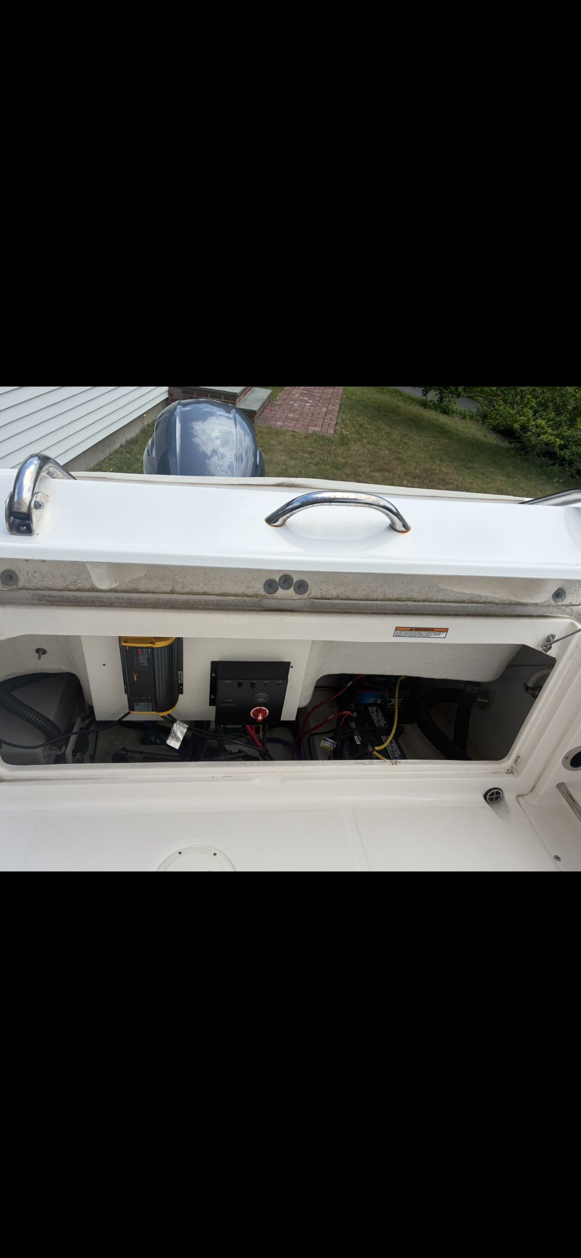 A 2019 Robalo R222 Center Console with open storage compartment and visible engine.